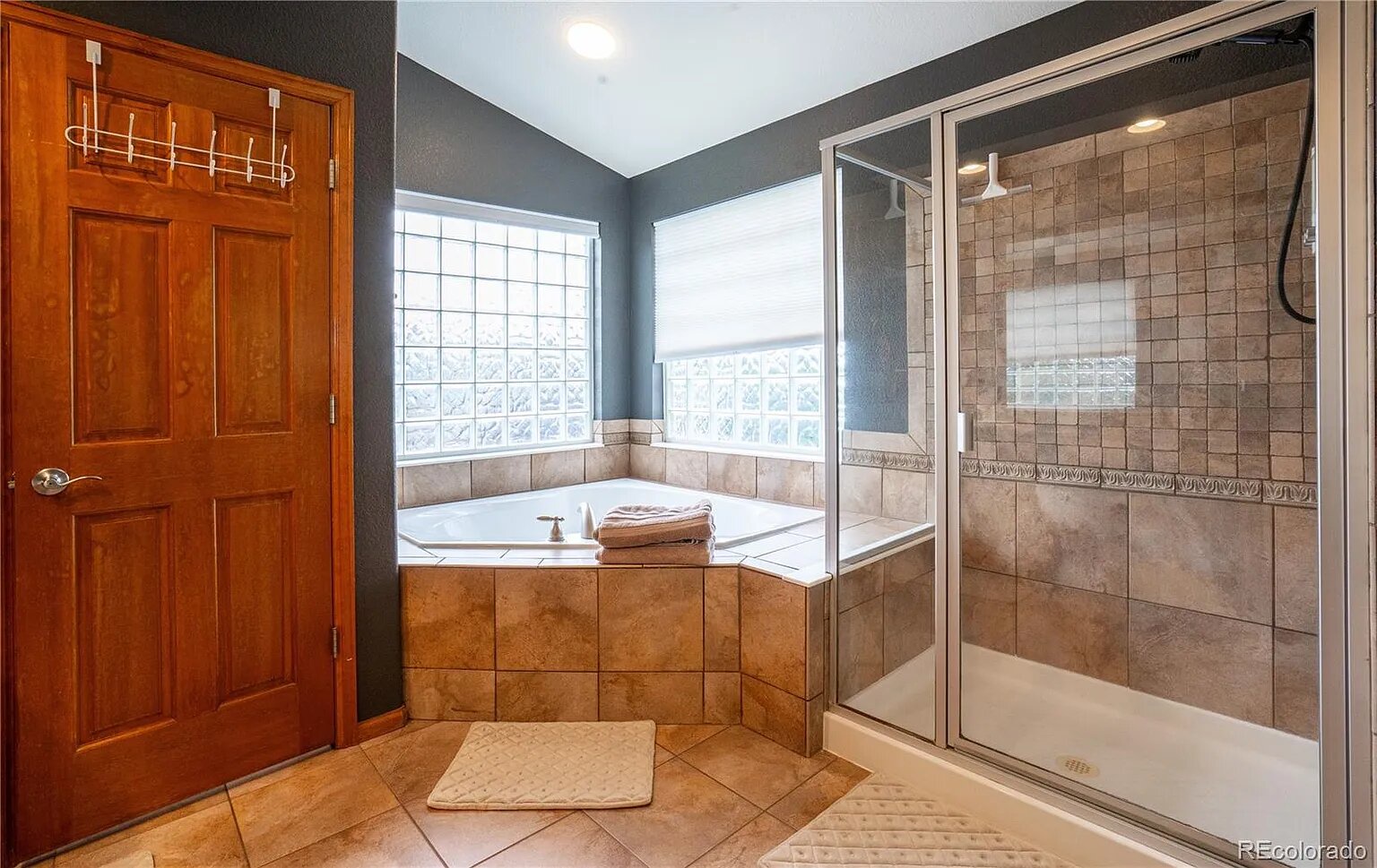 Soak your worries away in this elegant bathroom's corner tub or refresh in the spacious walk-in shower with beautiful tile work.