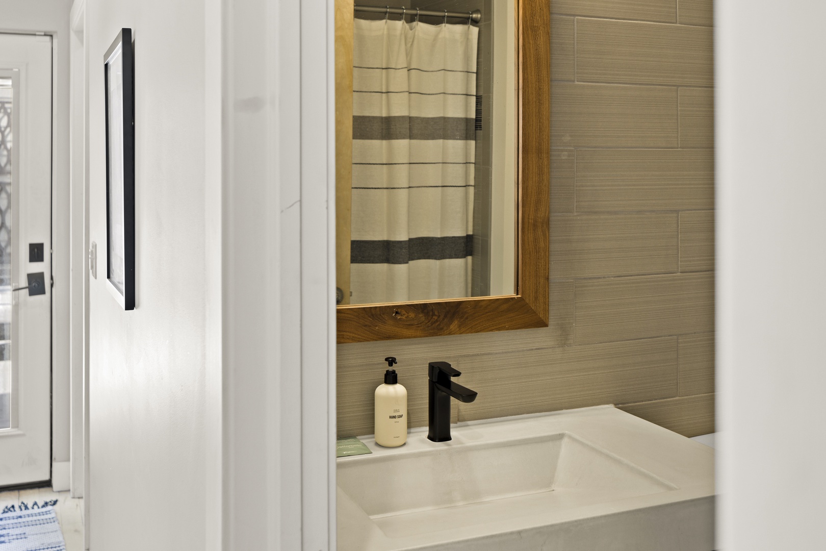 Your modern bathroom features sleek tile walls, a crisp vanity, and thoughtful amenities for your comfort.