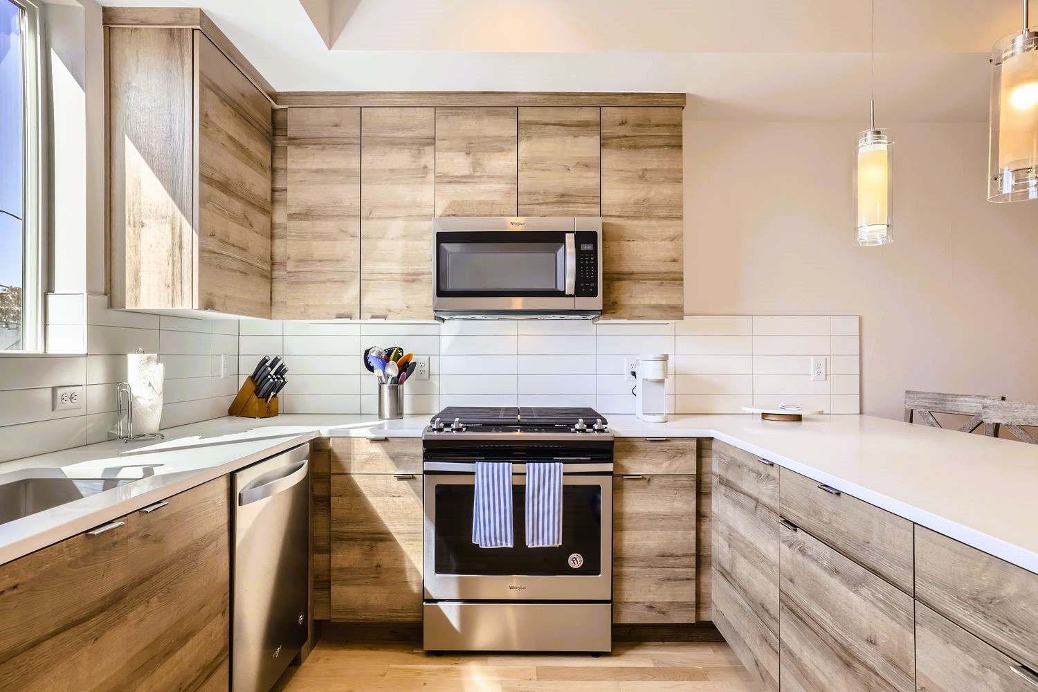 Your modern kitchen features warm wood cabinetry, gleaming quartz counters, and premium stainless appliances for effortless meal prep.