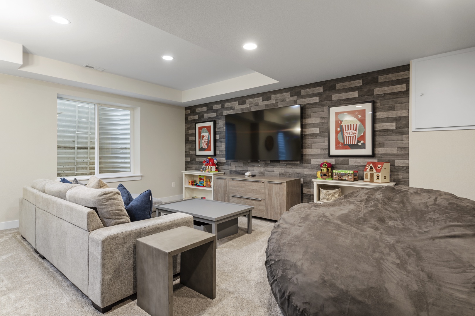 Sink into plush seating while your kids enjoy the play corner in this family-friendly entertainment room with large TV and cozy furnishings.