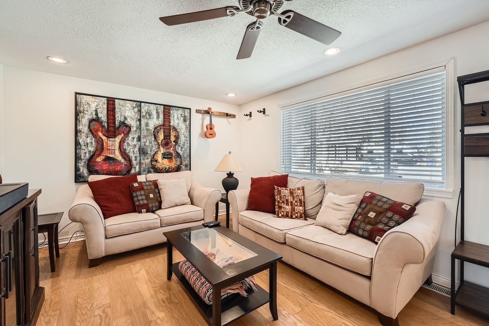 Settle into your cozy living room with plush sofas and musical art adorning the walls, creating the perfect space to unwind.