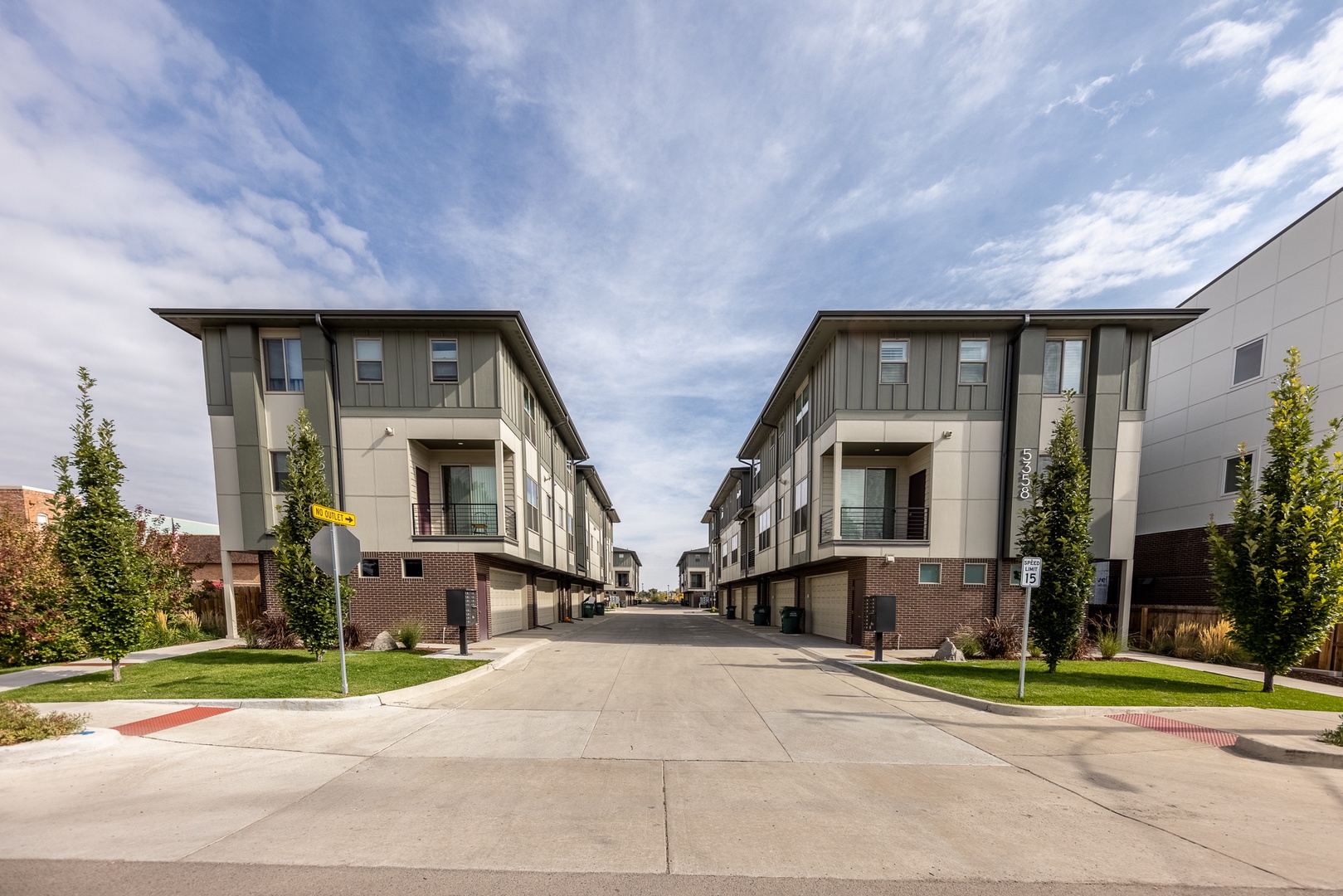 Modern townhome complex features contemporary architecture with landscaped grounds and convenient parking, located in a peaceful residential neighborhood.