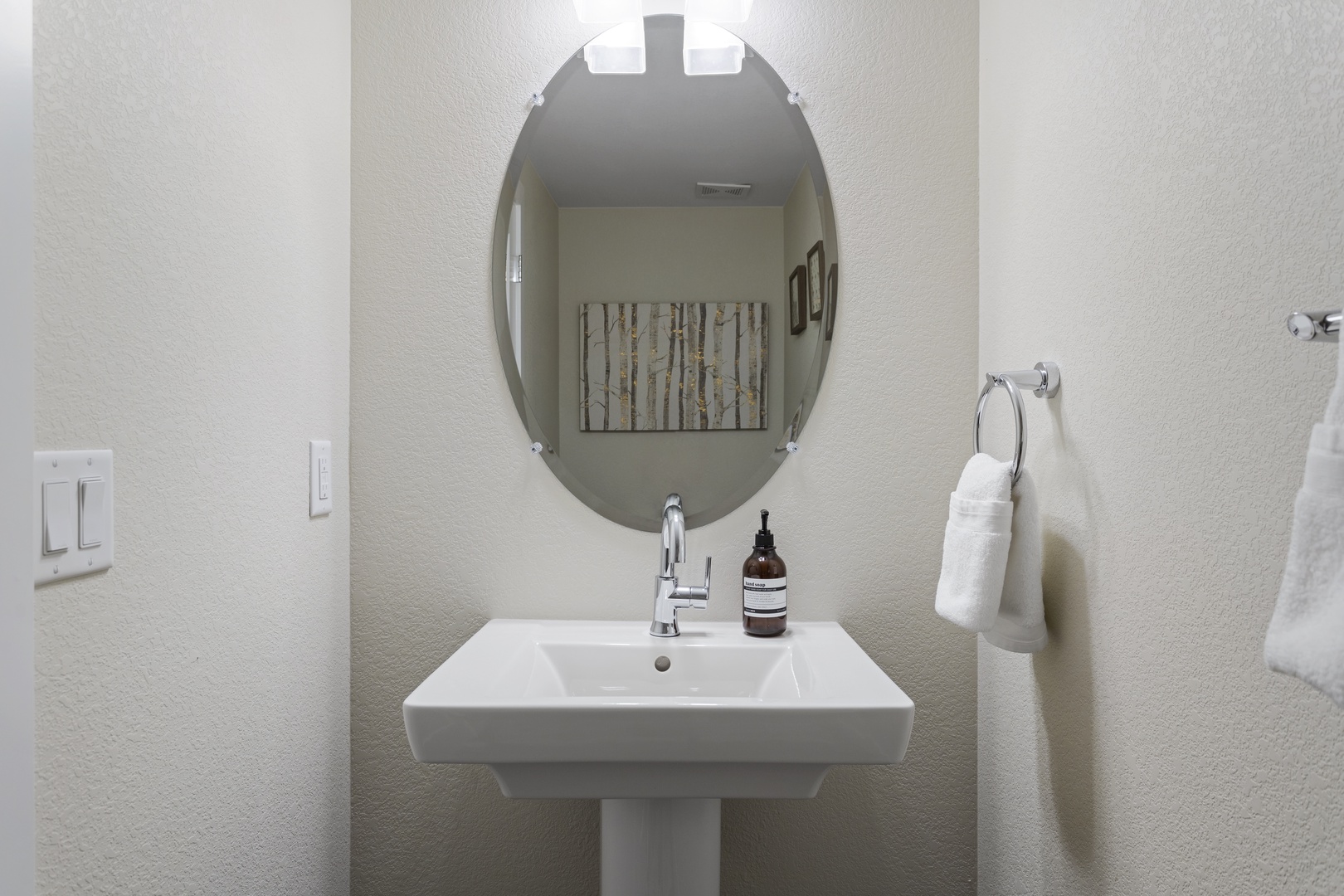 Freshen up in your stylish modern bathroom with sleek pedestal sink and thoughtful amenities awaiting your arrival.