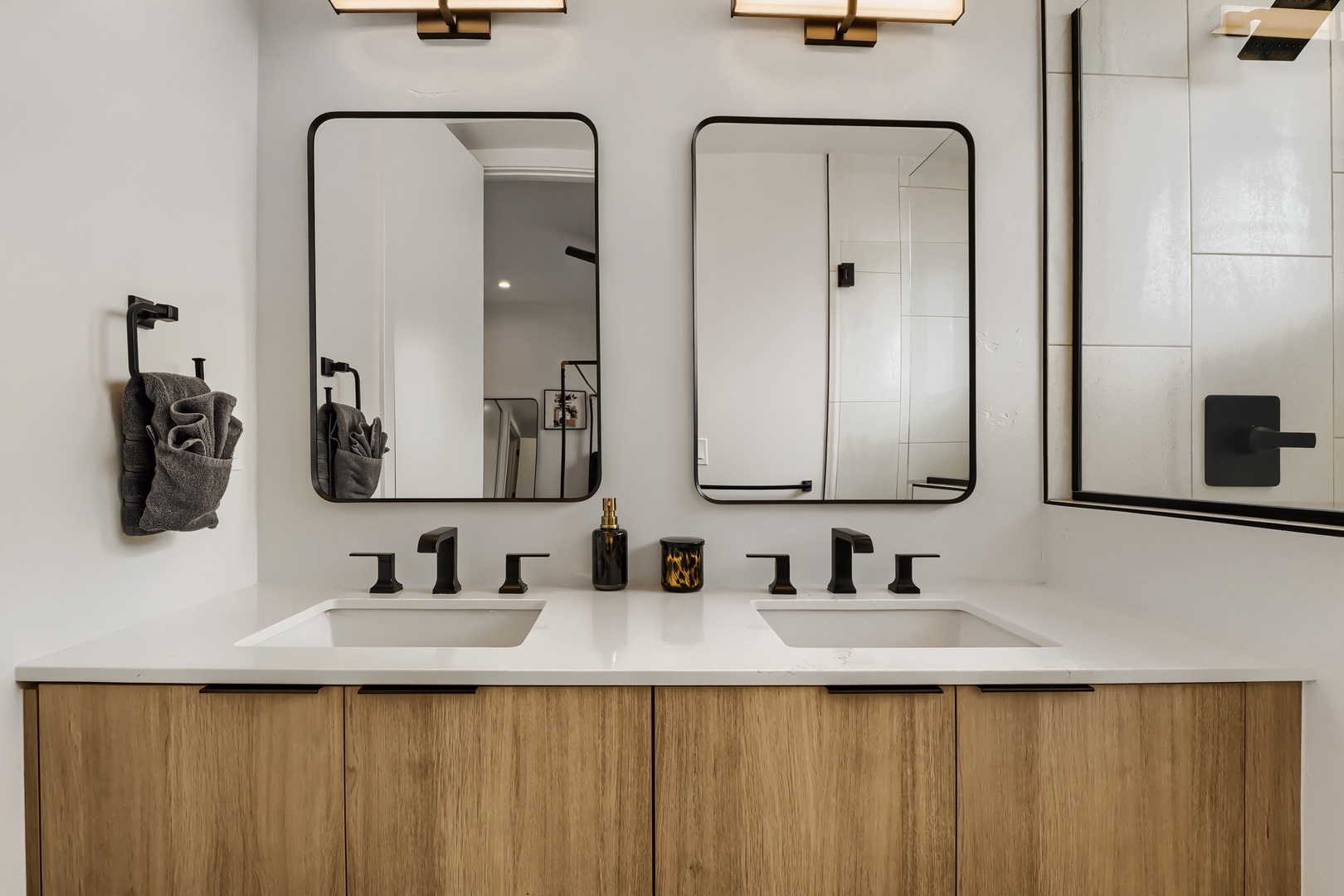 Refresh in your modern dual-sink bathroom, beautifully lit with warm gold accents and elegant black fixtures for a spa-like start to your day.