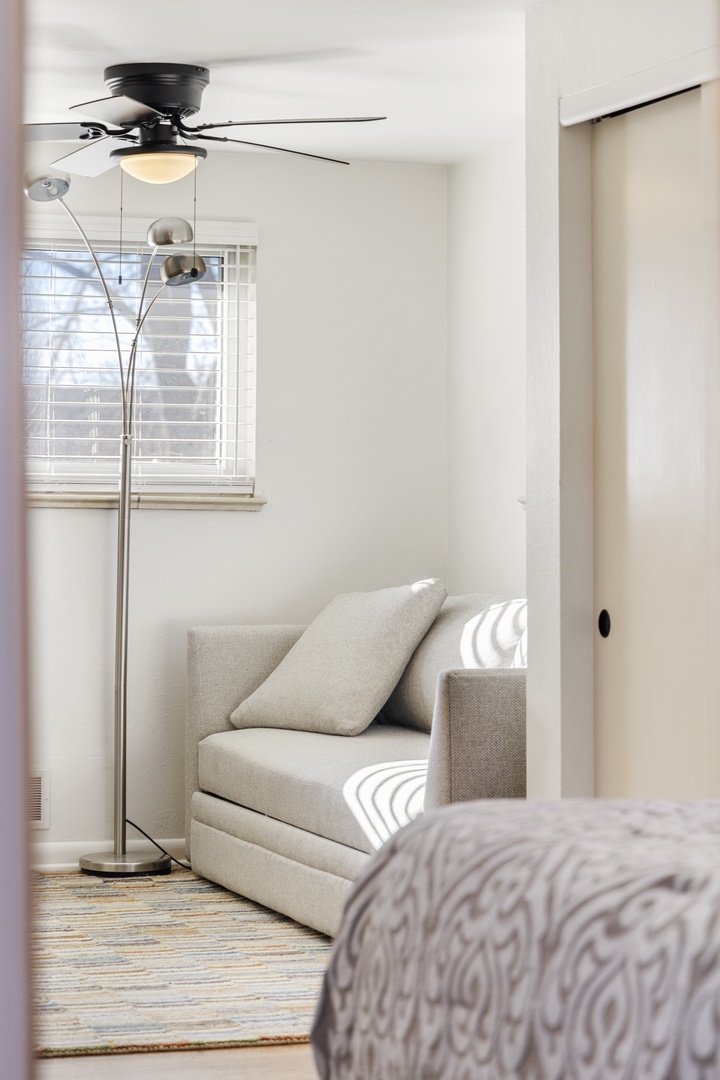 Unwind in your peaceful retreat with a cozy reading chair perfectly positioned by the bright window for those quiet moments.