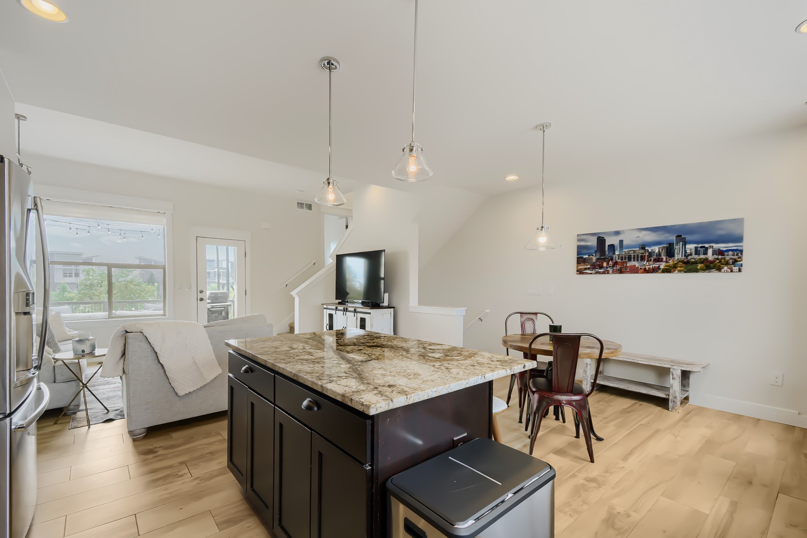 Light-filled living space where your group can gather around the granite island, relax on the sofa, or enjoy meals together at the dining table—all under elegant pendant lighting.