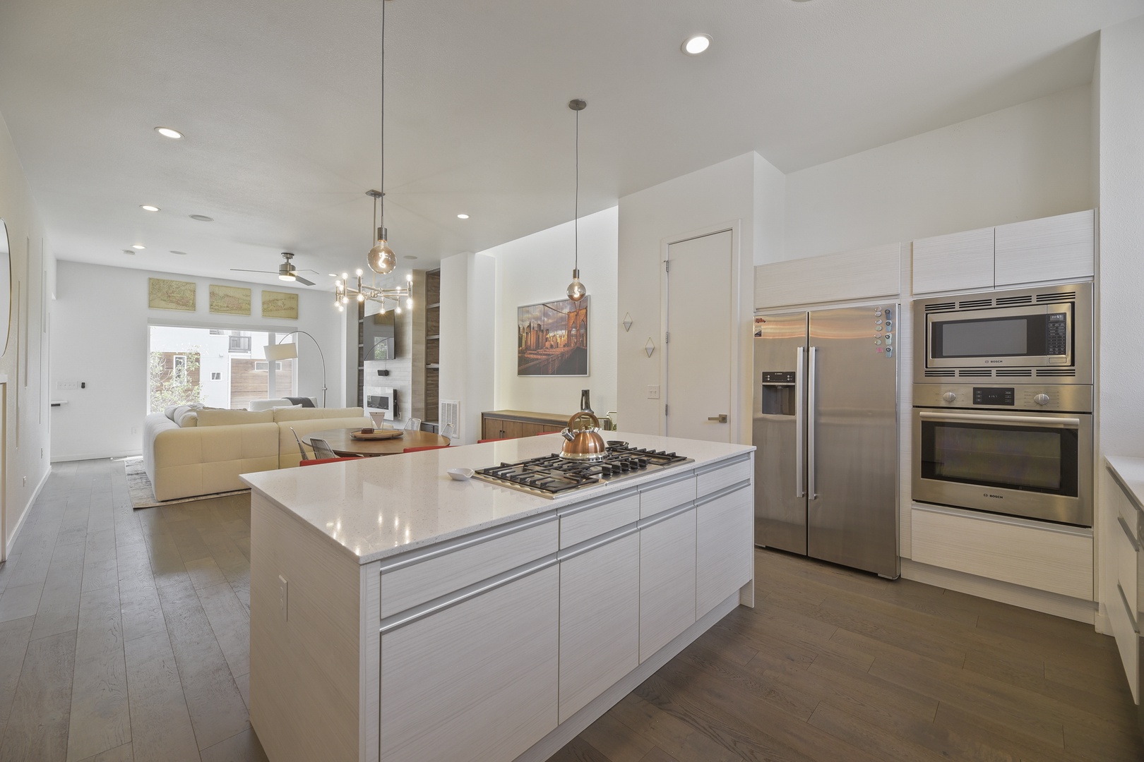 Step into your sleek, modern kitchen where gleaming white cabinetry, stainless steel appliances, and a spacious island invite you to cook, gather, and create lasting memories.