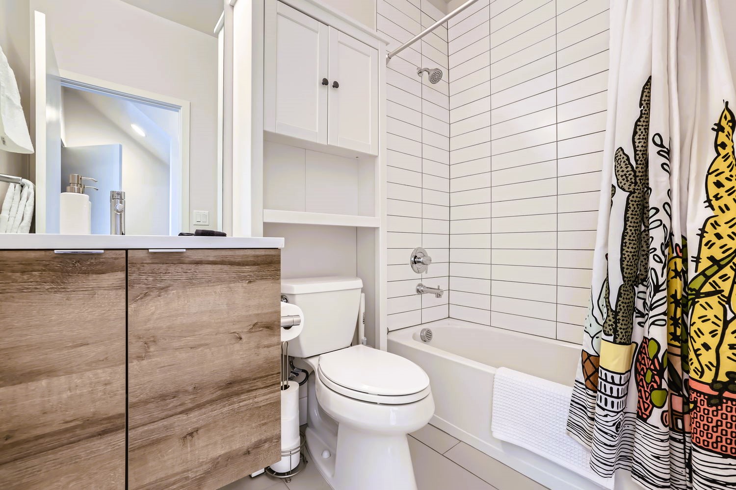 Step into your stylish bathroom featuring crisp white subway tiles, warm wood vanity, and cheerful artistic touches that make getting ready a joy.