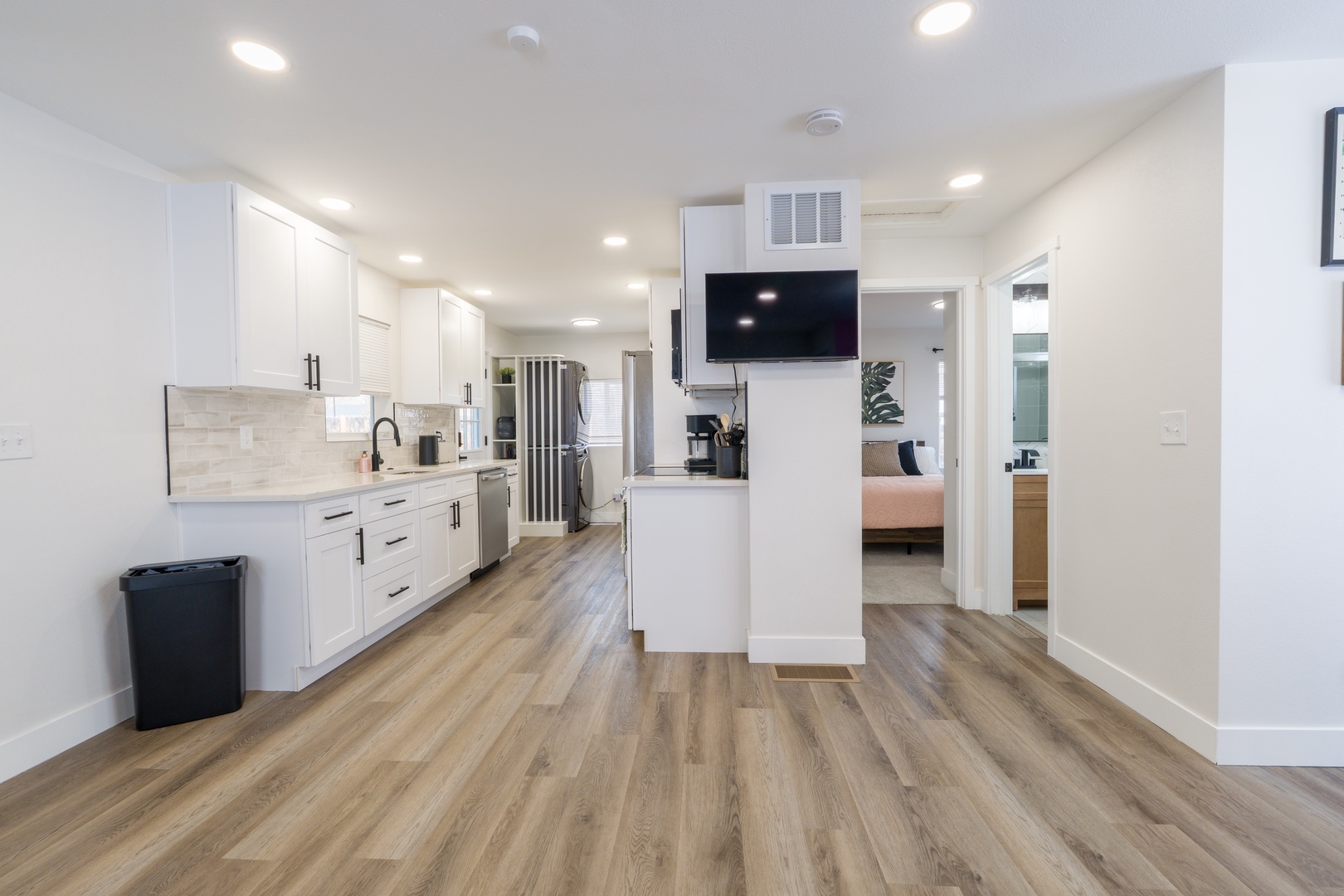 Your modern kitchen features sleek white cabinets, marble countertops, and stainless steel appliances with an open layout perfect for cooking and entertaining.