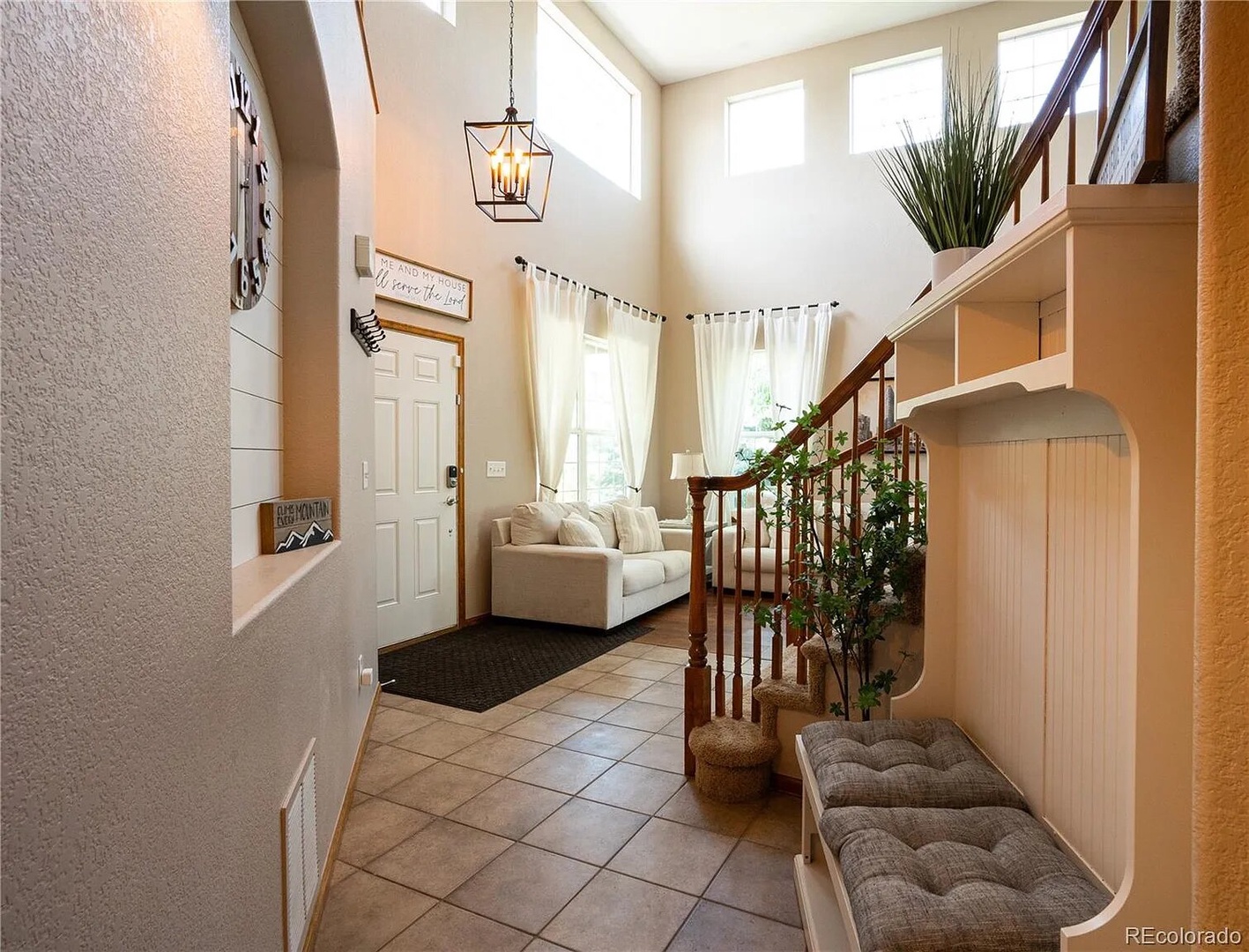 Step into your welcoming entrance where warm lighting and cozy seating create an instant sense of home and relaxation.
