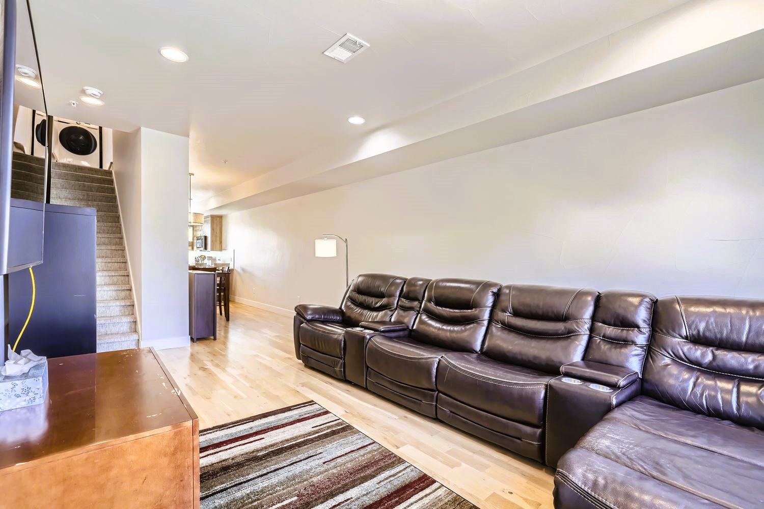Sink into plush leather seating in your spacious basement retreat, where gleaming hardwood floors and modern amenities create the perfect entertainment haven.