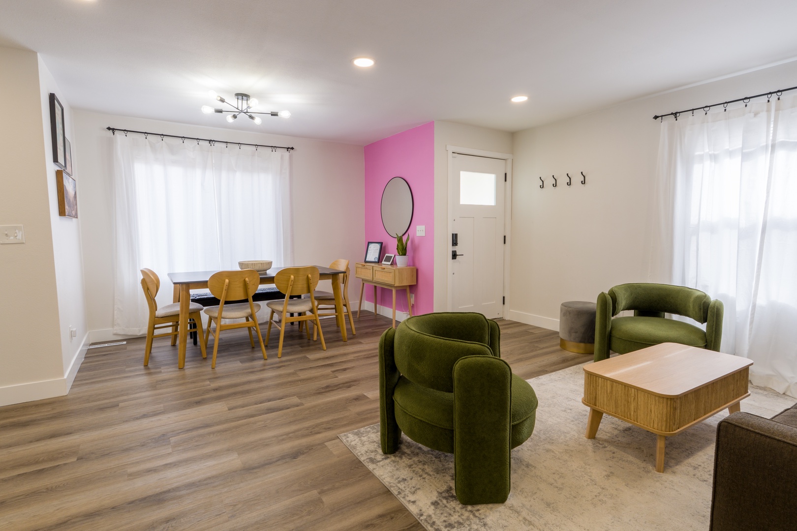 Relax in your stylish open-plan living space with plush velvet seating and warm wood dining table perfect for memorable meals.