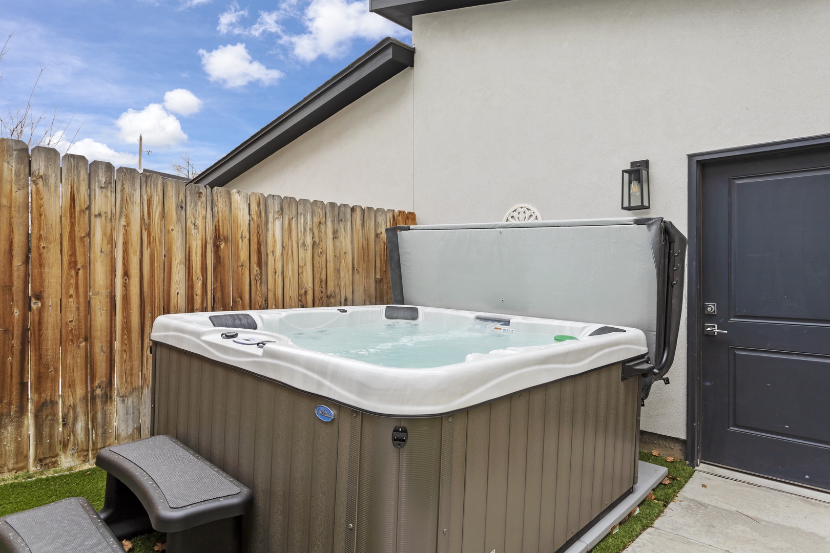 Slip into your private hot tub under open skies, where warm bubbling water melts away stress in your secluded outdoor retreat.