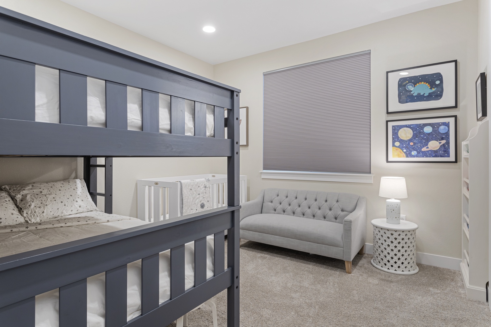 Settle into this stylish bedroom where your family can unwind together. Space-themed artwork sparks bedtime stories while plush seating invites quiet moments.