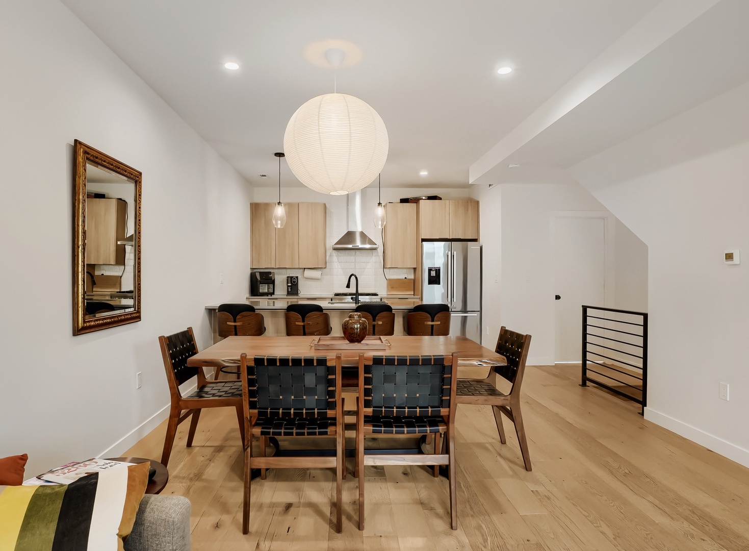 Gather around this inviting dining table and enjoy memorable meals together under the warm glow of modern lighting, with your open kitchen just steps away for effortless hosting.