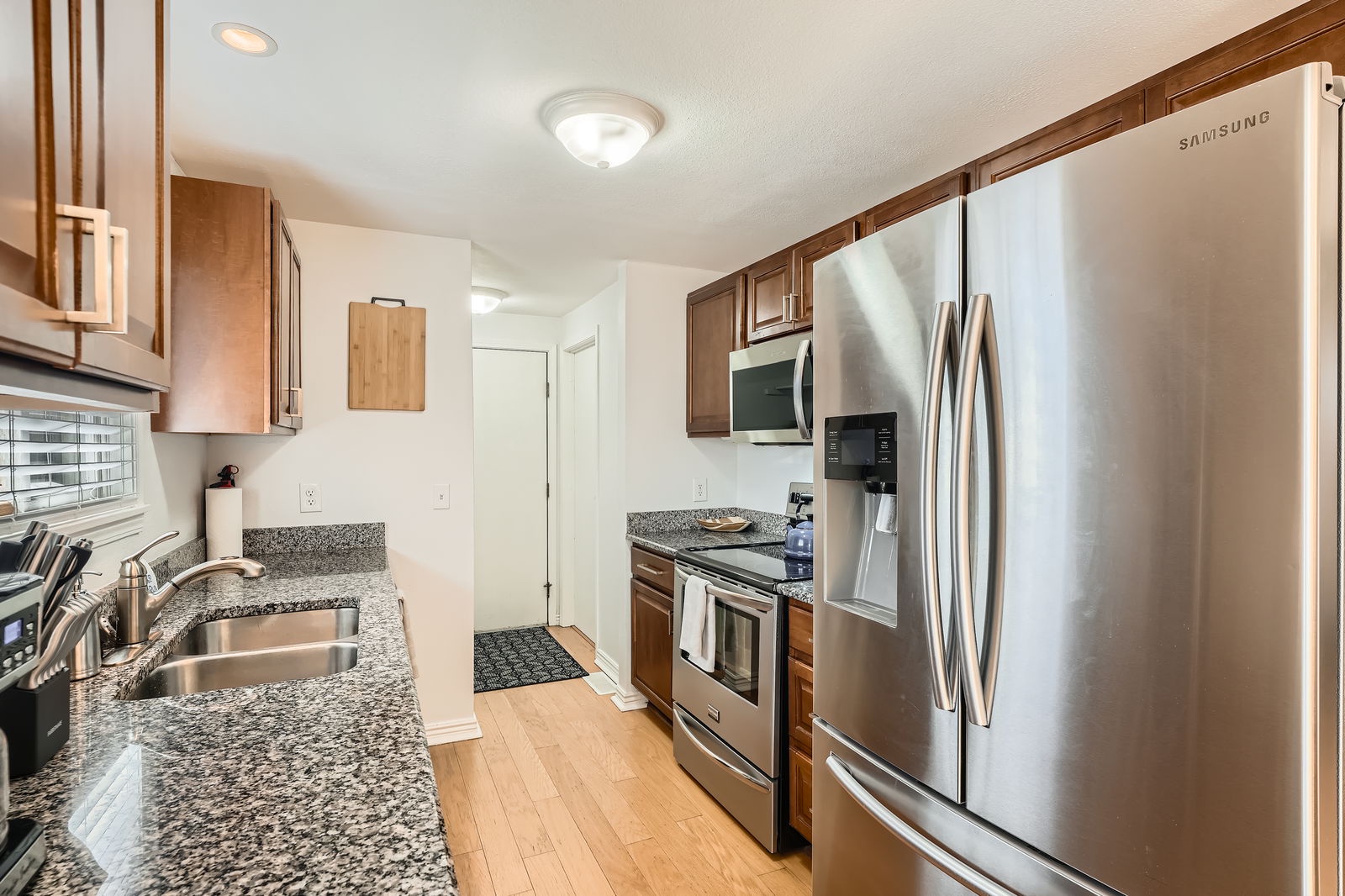 Your fully equipped kitchen features granite countertops, stainless steel appliances, and warm wood cabinetry for cooking memorable meals.