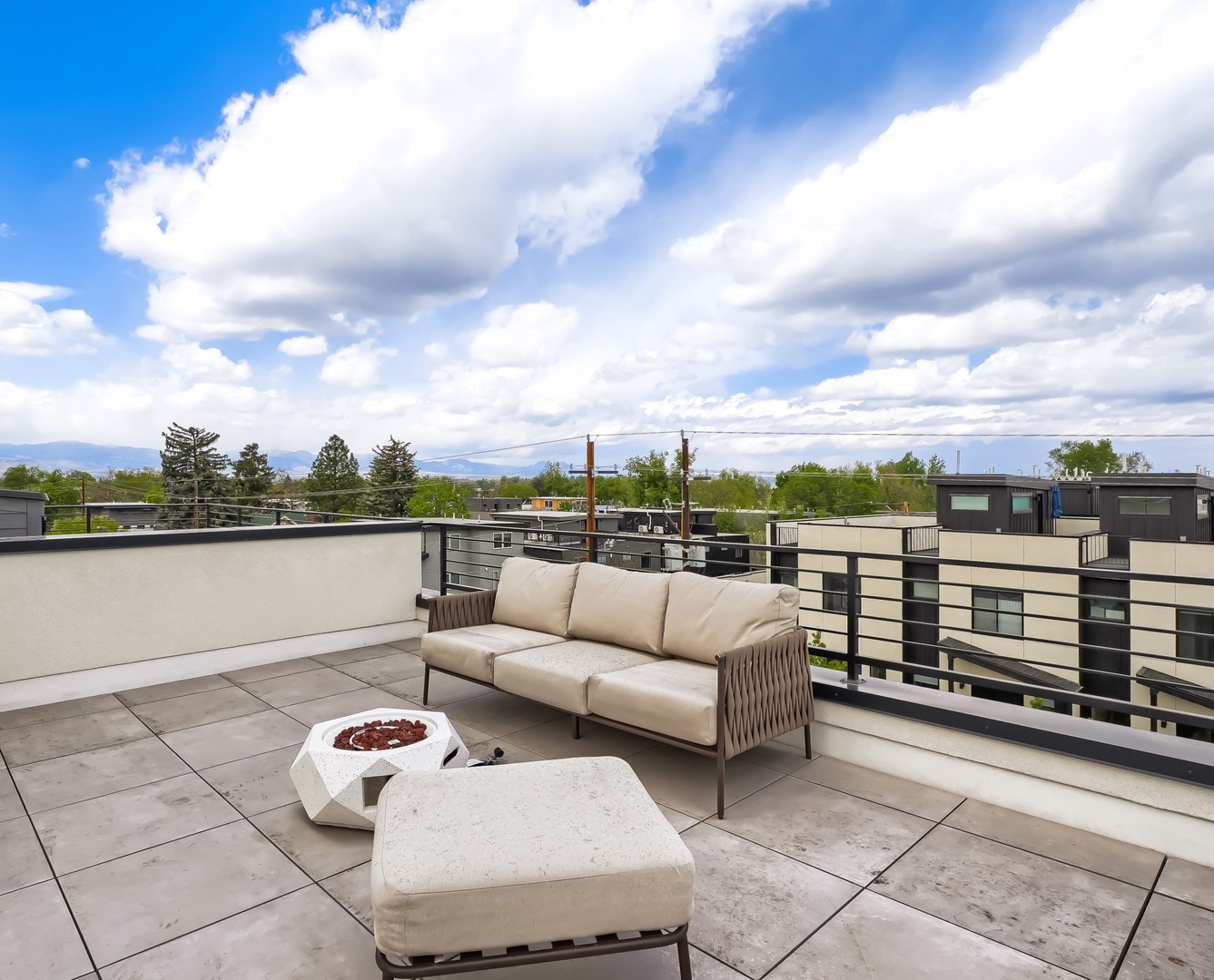 Step onto your private rooftop terrace and soak in sweeping mountain and neighborhood views. Relax on the cushioned sofa or gather around the fire pit as clouds drift overhead—your elevated escape for morning coffee or evening stargazing.