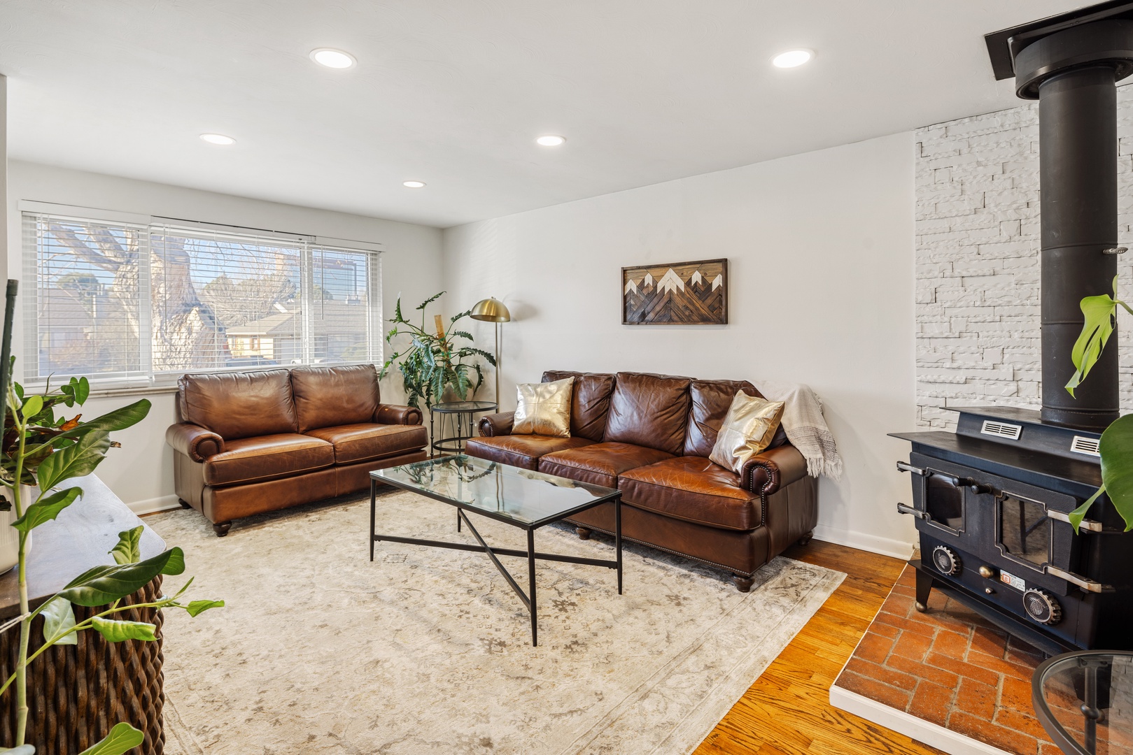 Sink into rich leather sofas by your cozy fireplace, where warm light and mountain art create the perfect retreat.