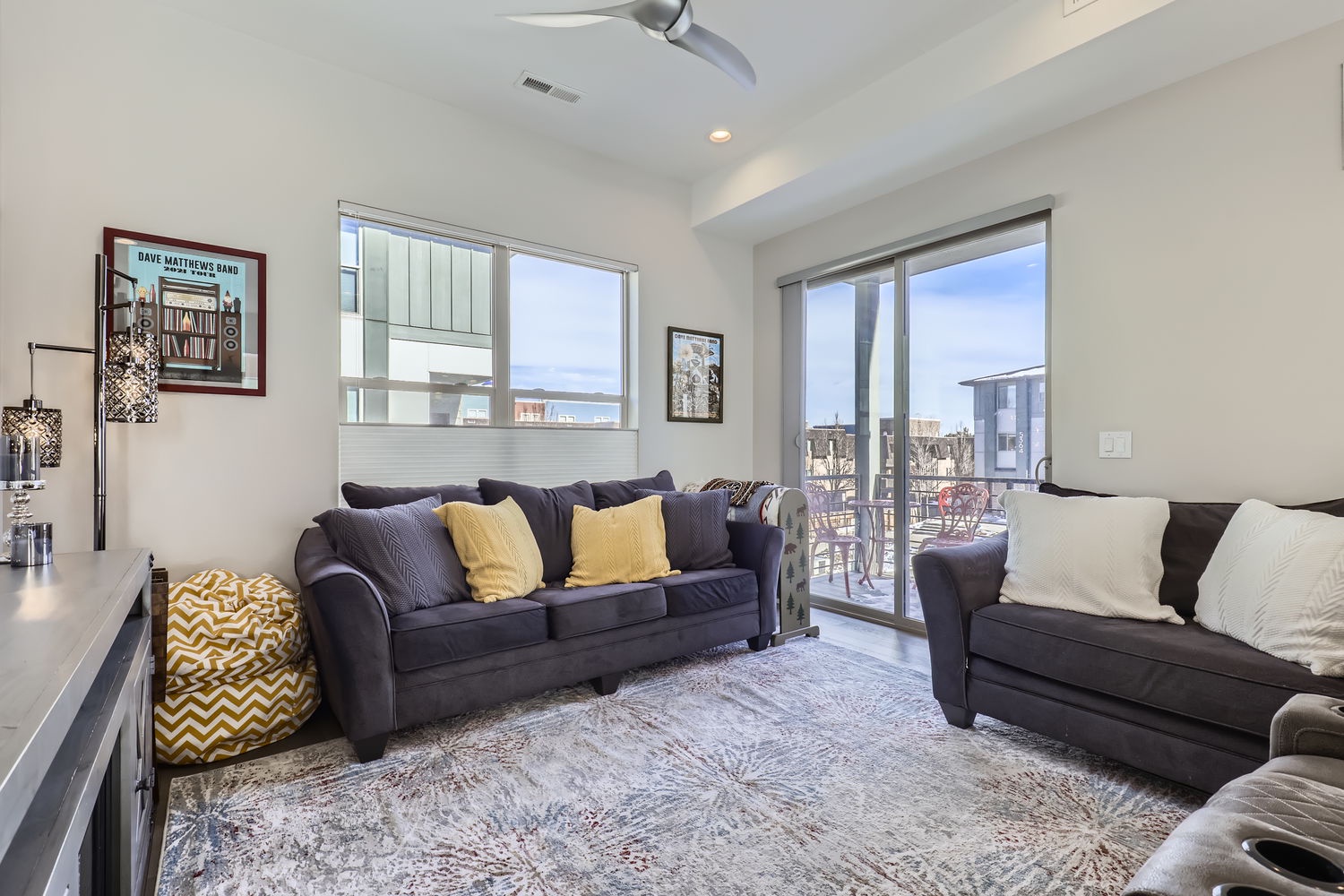 Unwind in your bright, modern living space with vaulted ceilings and contemporary furnishings. Large windows flood the room with natural light, while the balcony invites you to step outside and soak in the surrounding views.