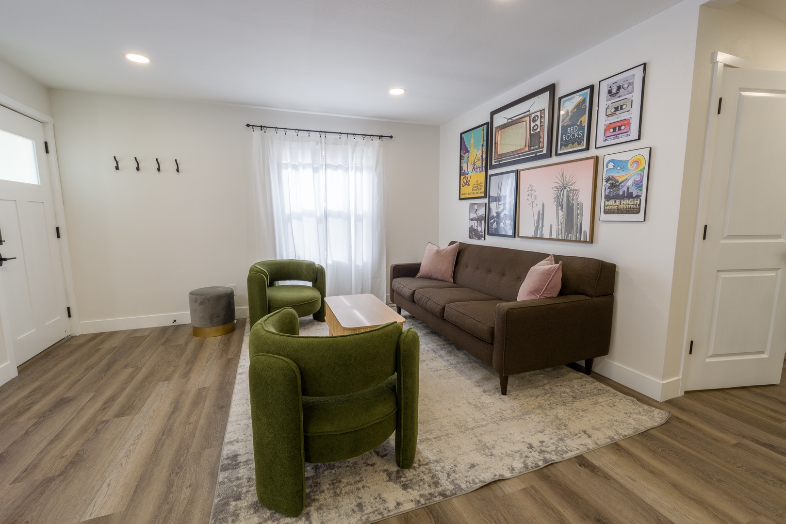 Sink into plush seating surrounded by curated art in your stylish living space, where natural light creates the perfect atmosphere for relaxation.