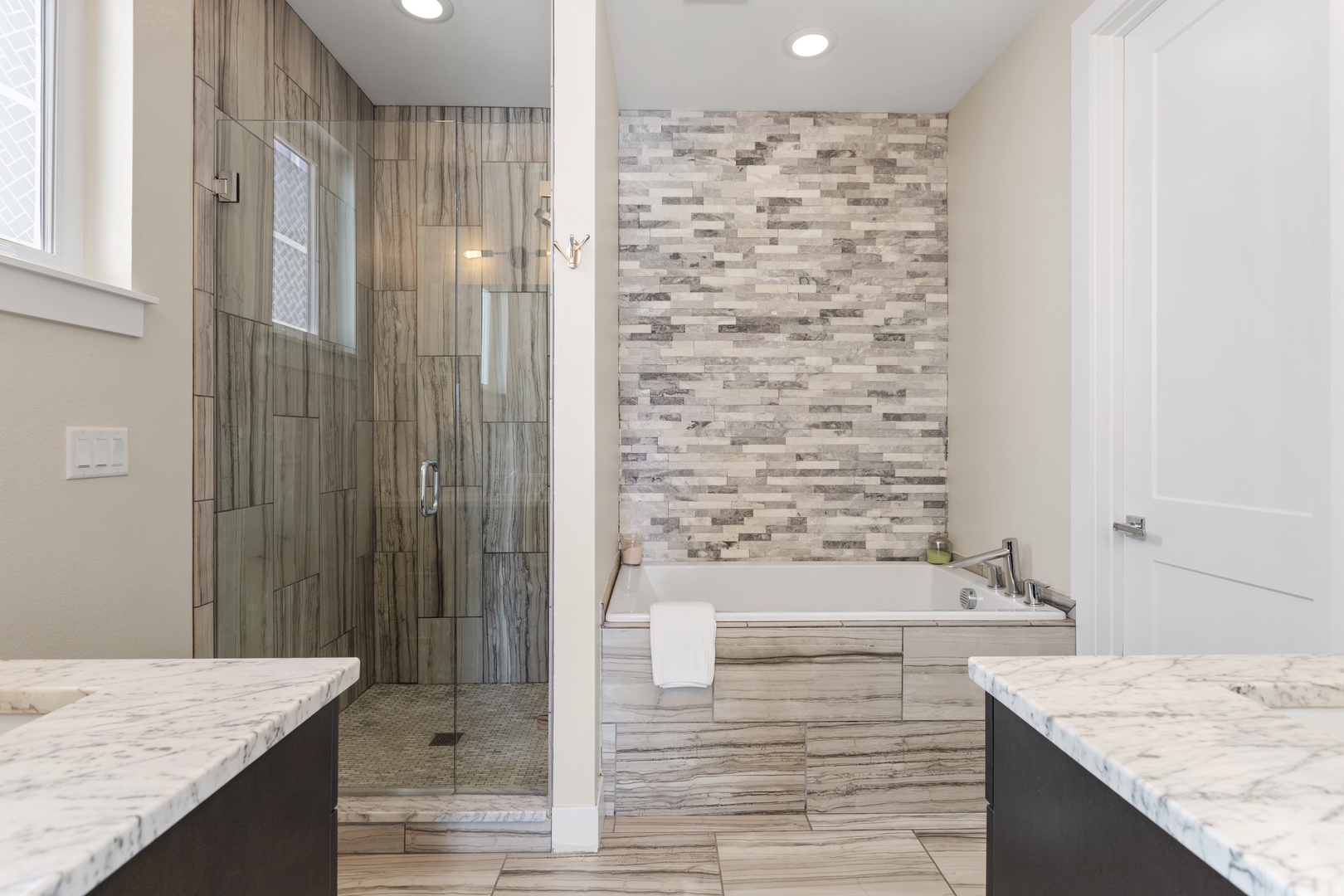 Indulge in your private spa retreat with luxurious marble counters, rainfall shower, and soaking tub for ultimate relaxation.