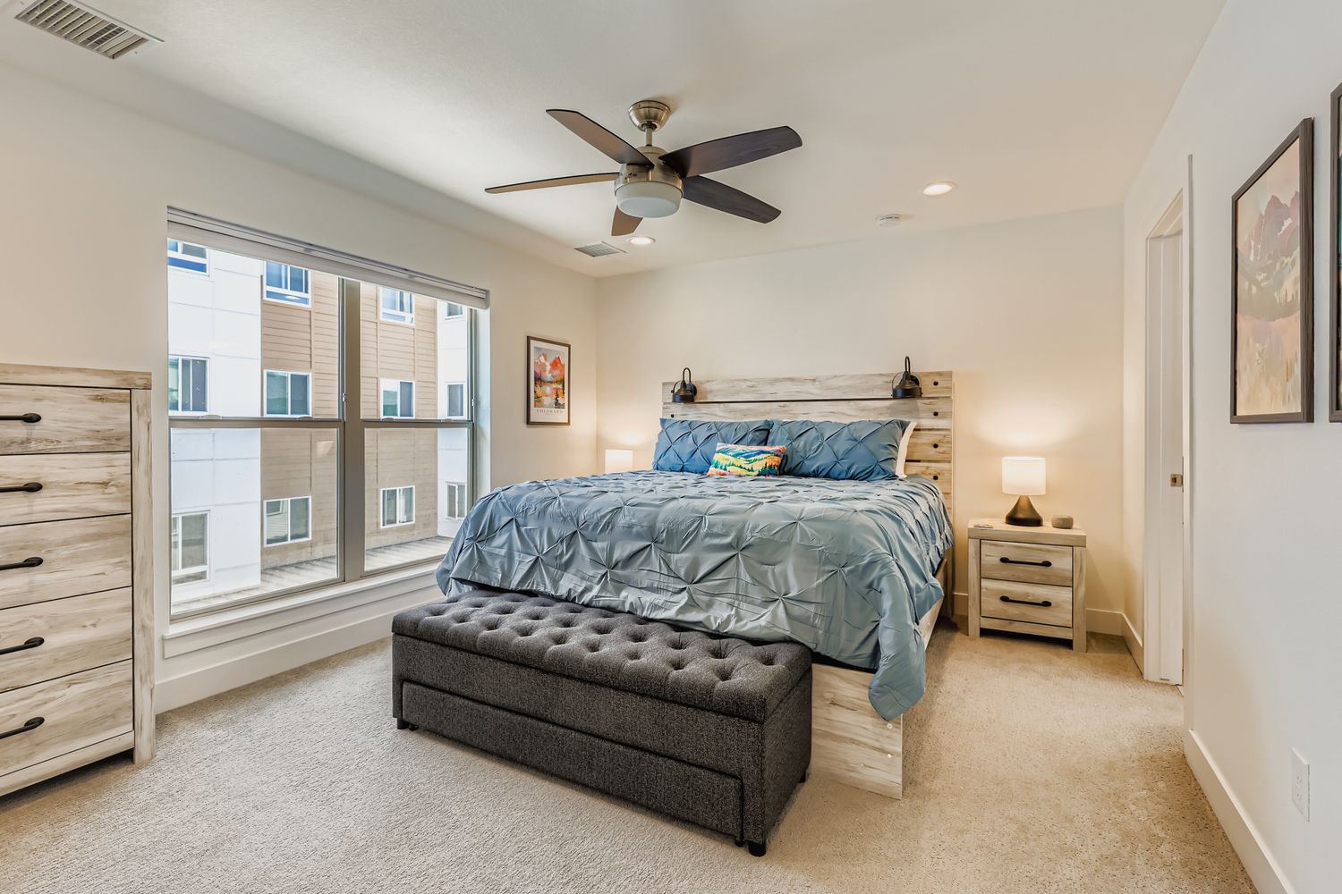 Drift off to sleep in this peaceful bedroom with its plush bedding and soft lighting. Wake refreshed, with natural light streaming through your window and a gentle ceiling fan to keep you comfortable.