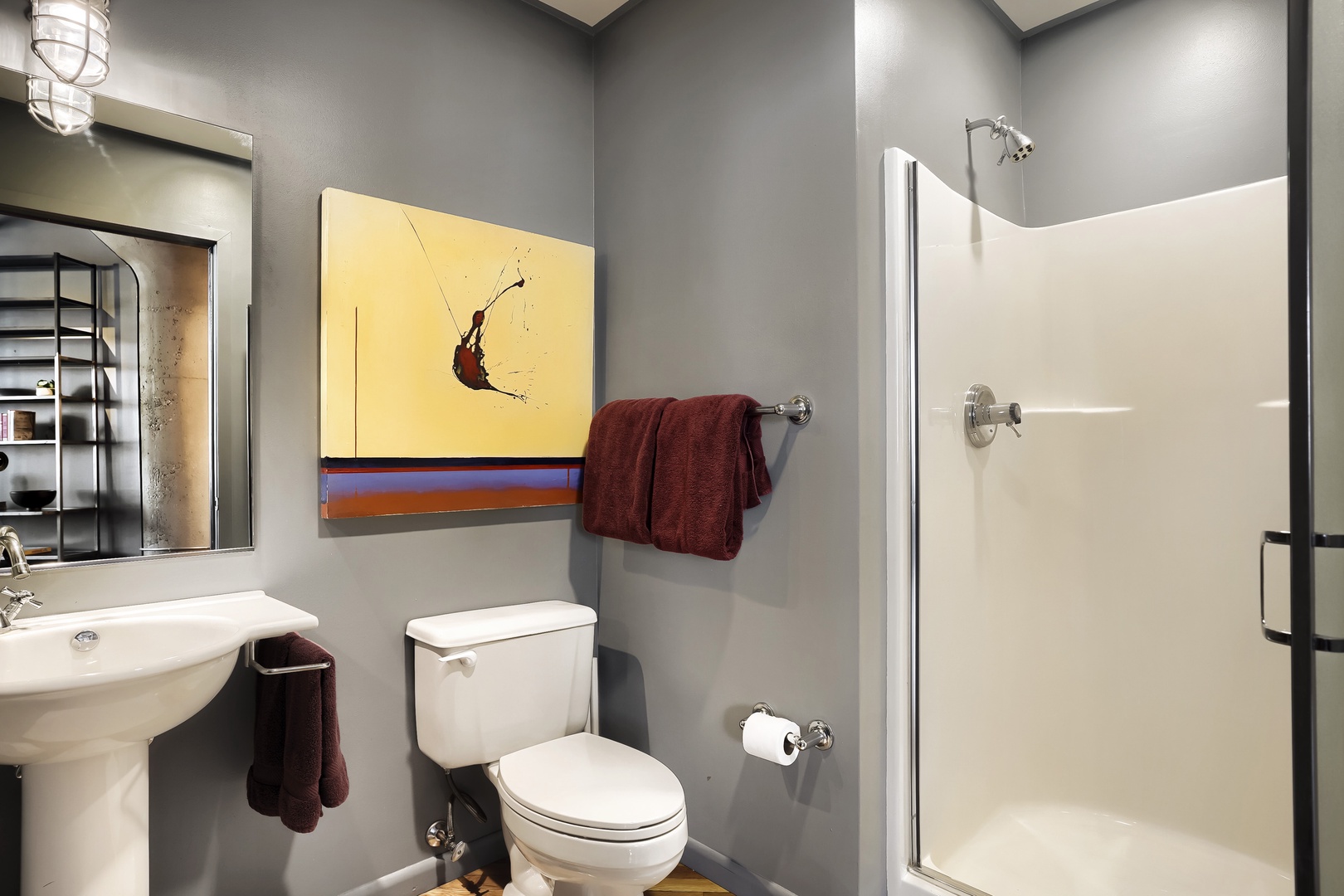 Step into your modern bathroom with sleek gray walls, a crisp white shower, and thoughtful touches like fresh towels and artistic décor that welcome you home.