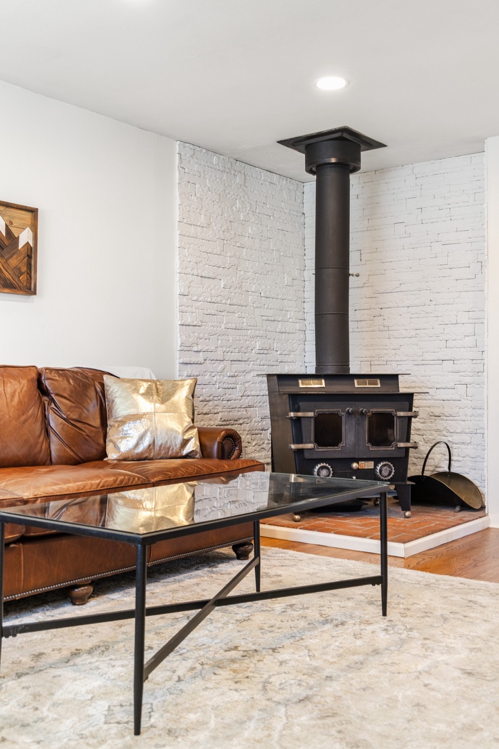 Cozy up on the rich leather sofa by your own wood-burning fireplace, where white brick walls and warm touches create the perfect spot to unwind.