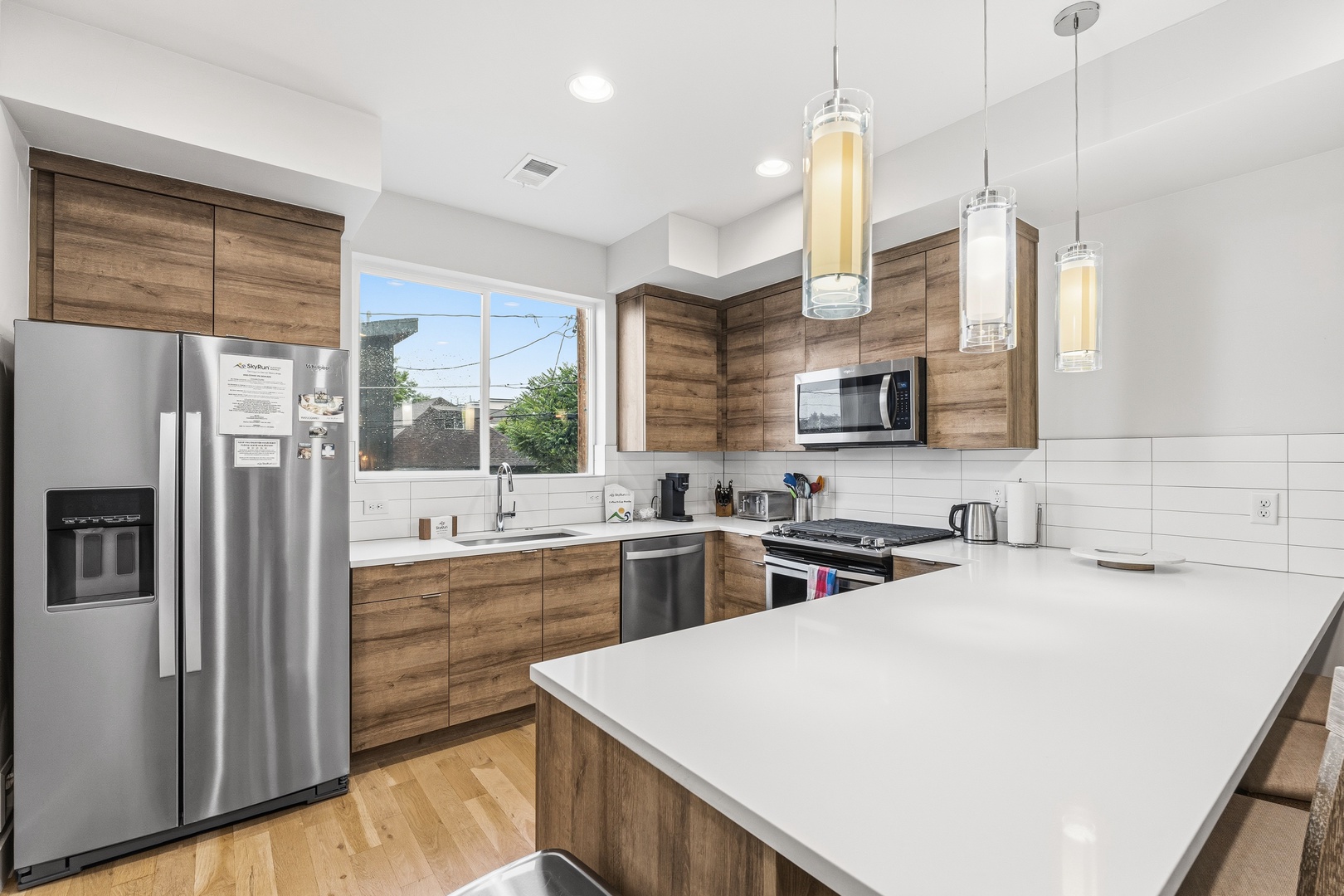Your modern kitchen features warm wood cabinetry, gleaming stainless appliances, and a spacious island—perfect for whipping up your favorite meals or gathering with loved ones over morning coffee.
