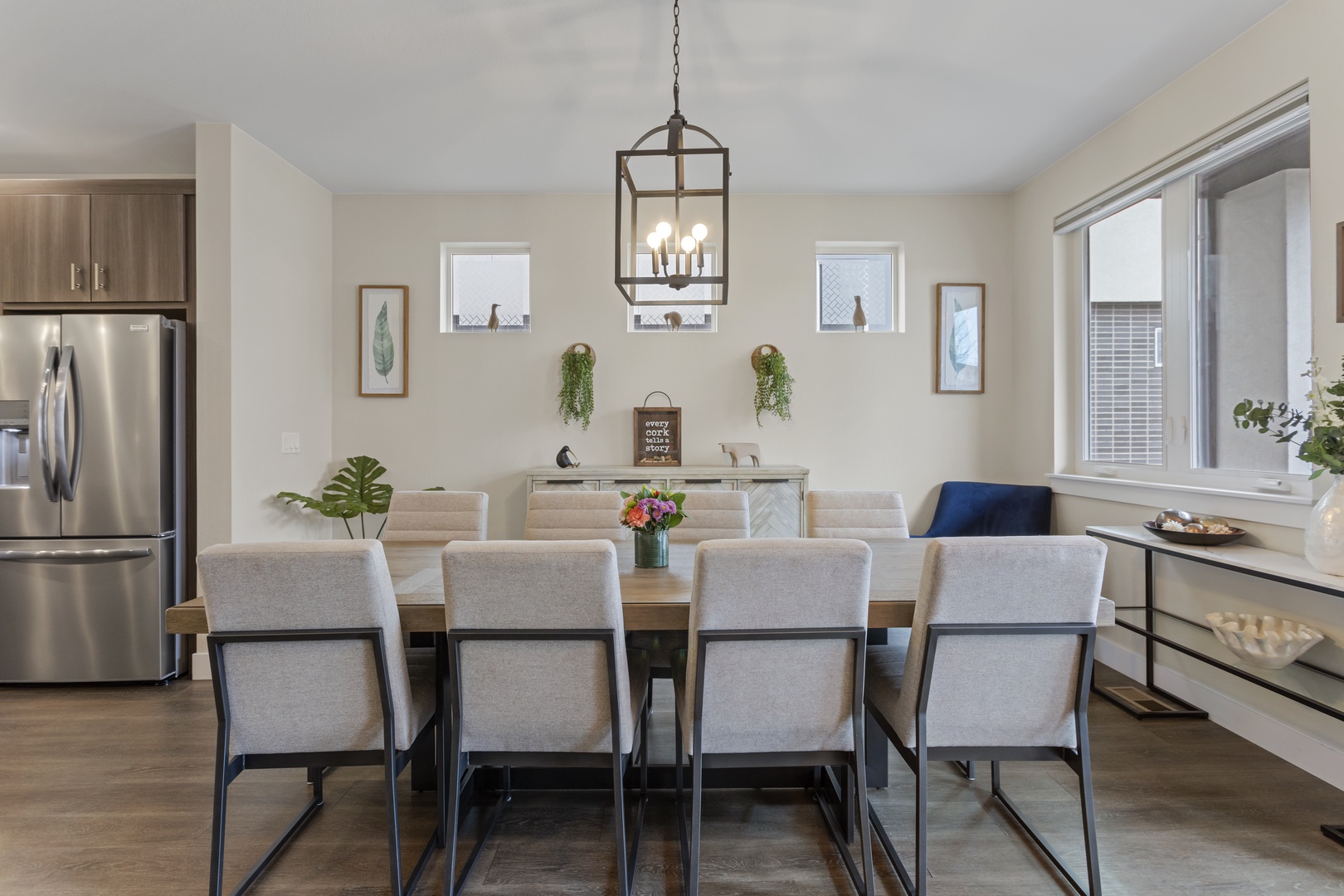 Gather around this elegant dining table where memorable meals unfold under warm pendant lighting, with modern kitchen conveniences just steps away.