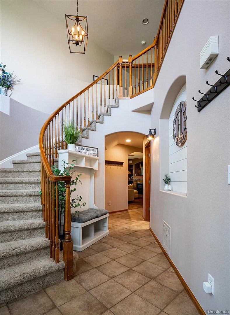 Your grand entrance welcomes you with soaring ceilings, elegant chandelier lighting, and a stunning curved staircase that sets the tone for your stay.