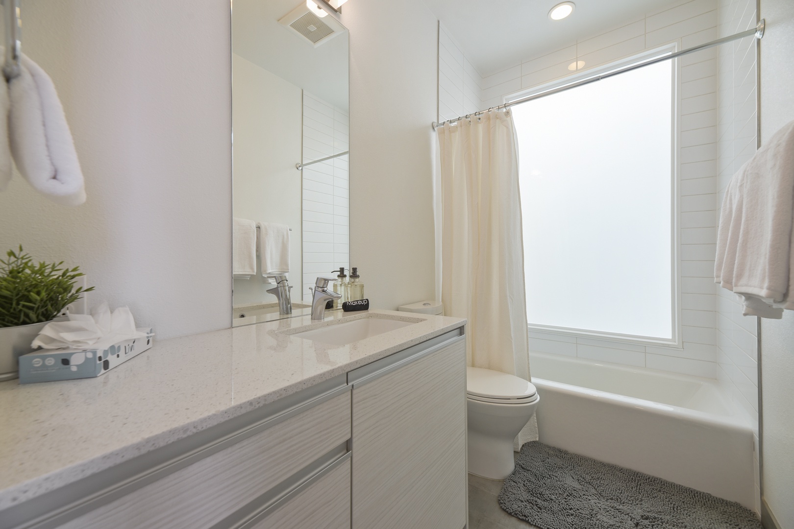 Refresh in your private bathroom with crisp white subway tiles, a soothing tub-shower combo, and plush towels waiting for you after a day of exploring.
