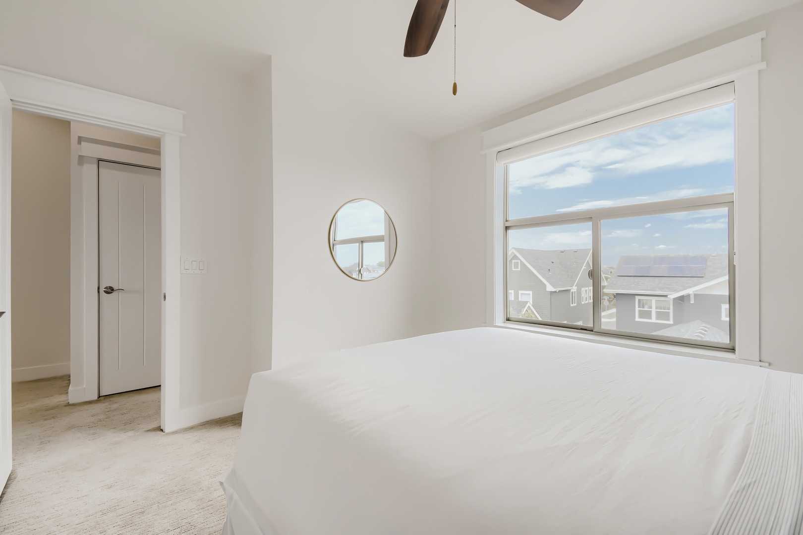 Sink into crisp white linens in your peaceful bedroom. Natural light pours in while the ceiling fan above keeps your retreat comfortably cool.