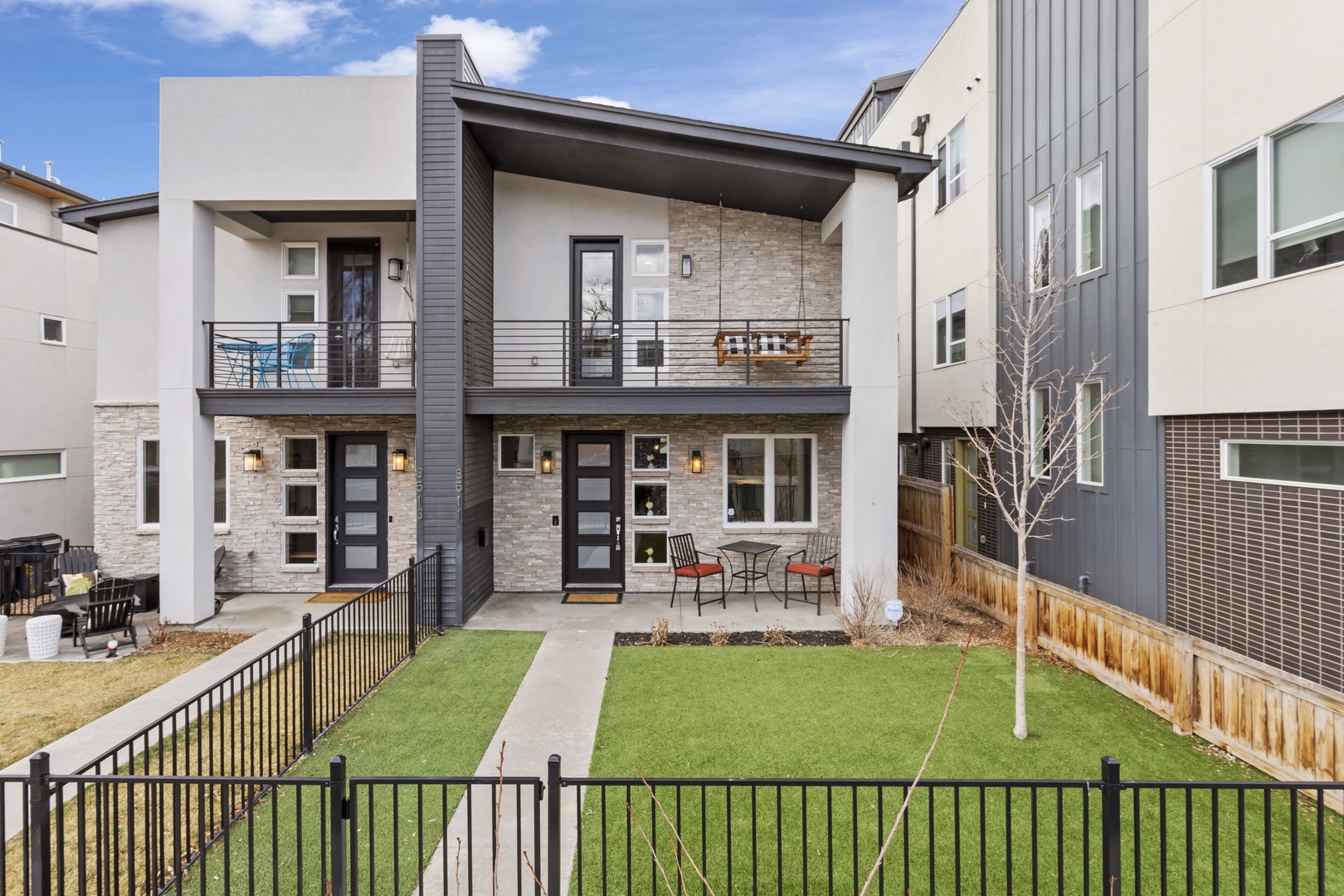 Modern two-story duplex featuring stone accents and contemporary design in a quiet residential neighborhood.