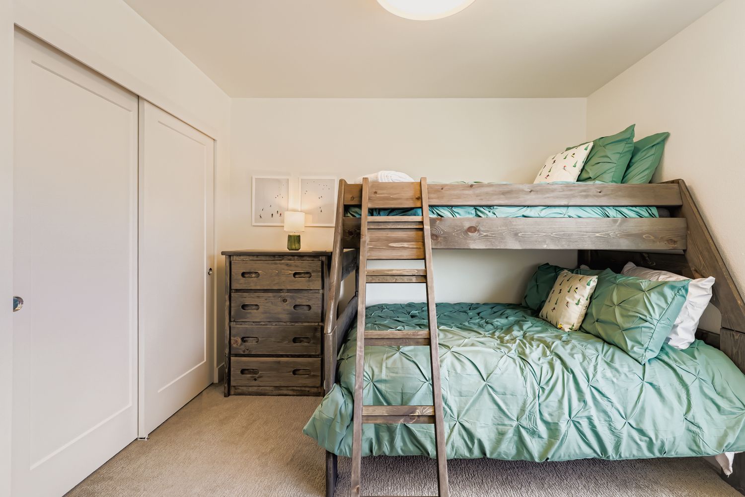 Cozy bunk bed setup perfect for kids, featuring calming sea-green linens and charming patterned pillows. Your little ones will love this comfortable sleeping space with its rustic wooden frame and thoughtful touches.