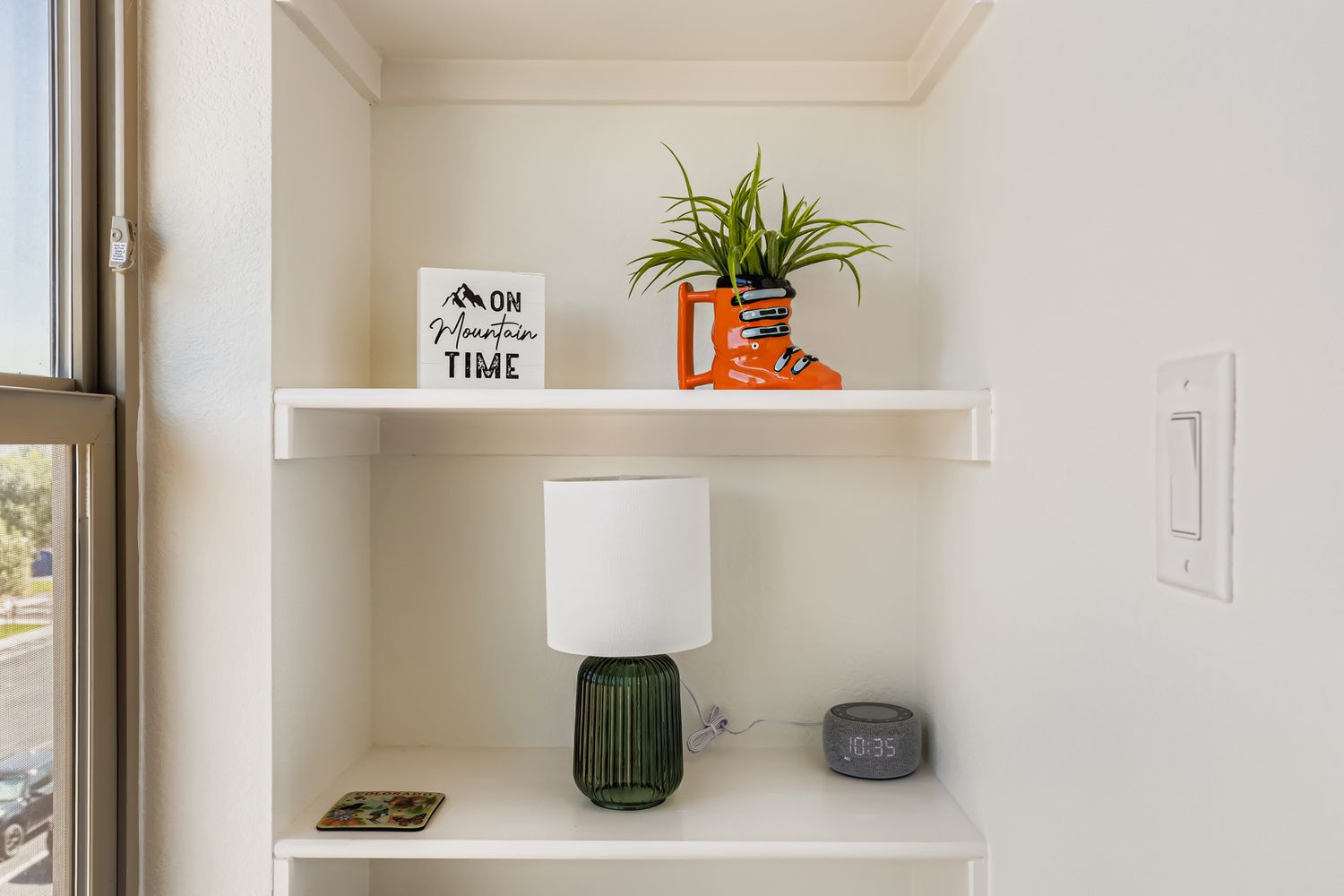 Your thoughtfully styled shelves add personality to the space, with a cheerful plant and mountain-themed decor creating a cozy, inviting nook perfect for your morning coffee or evening wind-down.