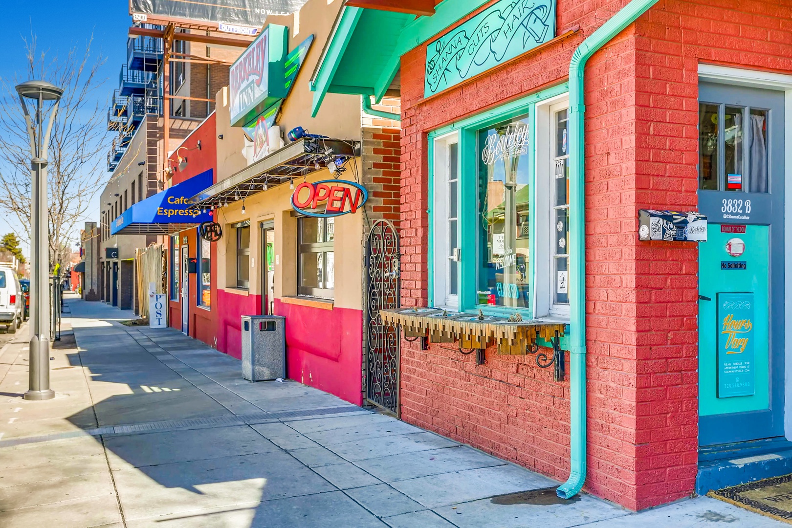 A vibrant neighborhood street lined with colorful local shops and cafés, offering a welcoming glimpse of the area's character and nearby conveniences.