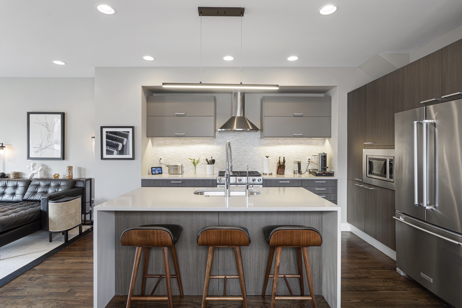 Cook and gather in your sleek modern kitchen with stainless steel appliances, quartz island seating, and open connection to the living area.