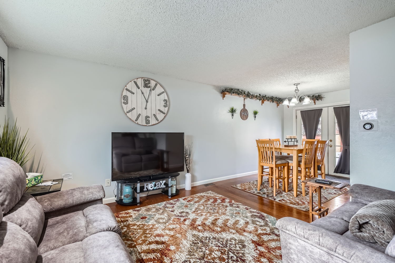 Settle into soft, welcoming seating in your spacious living area, where natural light, rustic touches, and warm wood floors create a relaxing retreat for your entire group.