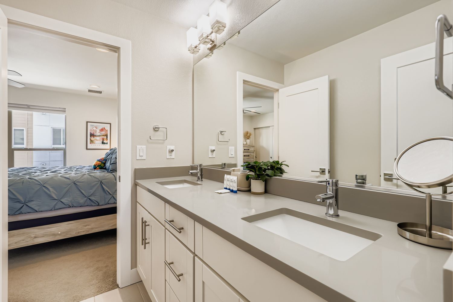 Your private ensuite bathroom features dual sinks with elegant countertops and modern fixtures, plus direct access to the bedroom with its walk-in closet—perfect for getting ready each morning.