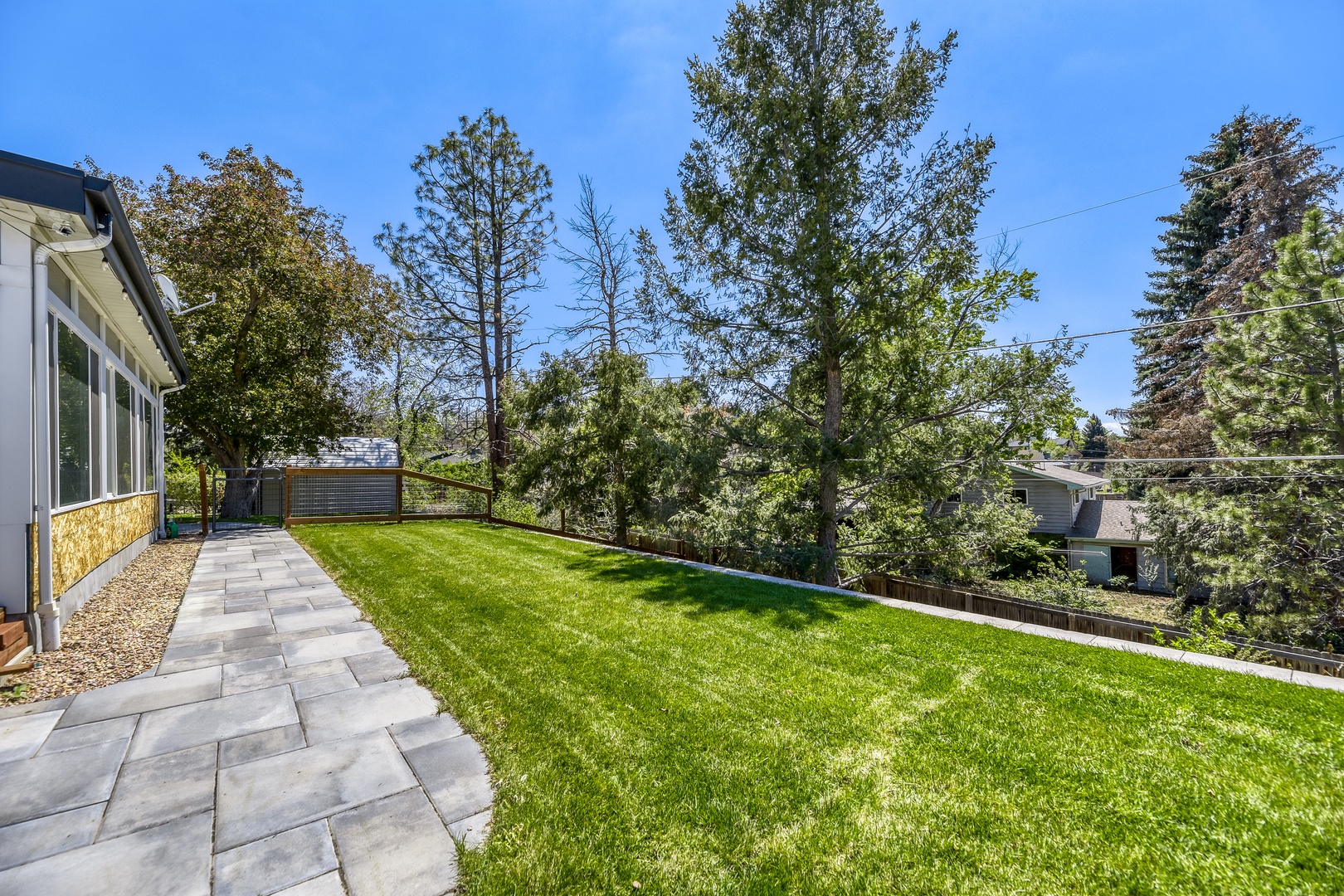 This spacious, tree-lined yard offers a peaceful escape with lush green lawn, mature shade trees, and ample space for outdoor relaxation or activities.