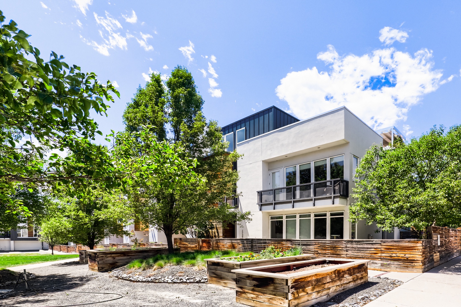 Modern vacation rental nestled in a tree-lined neighborhood with private outdoor garden spaces and balconies for relaxation.