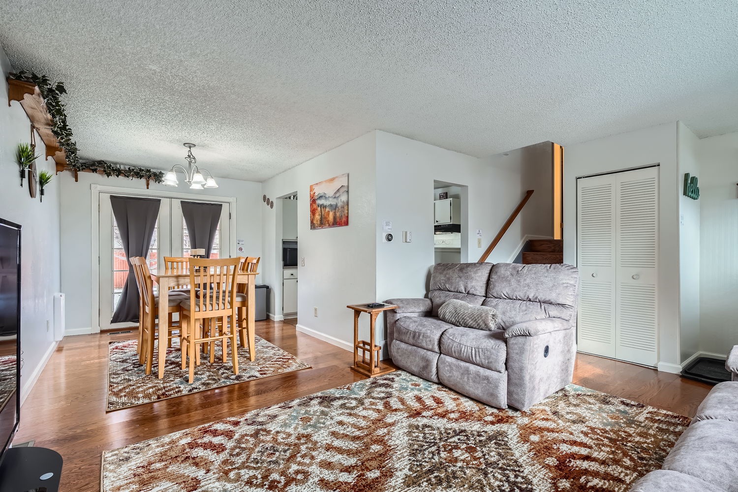 Gather around the dining table or relax on the plush sofa in this bright, open living space. Warm wood floors and cozy touches make you feel right at home from the moment you arrive.