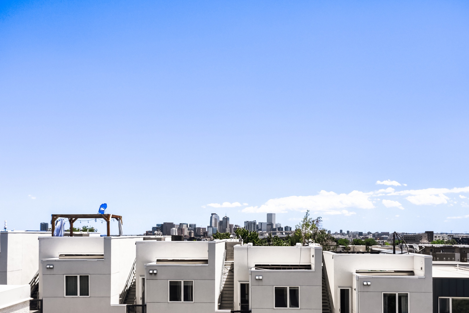 Modern rooftop complex featuring multiple levels with private terraces and urban skyline views. The property is located in a vibrant city neighborhood with convenient access to downtown attractions.