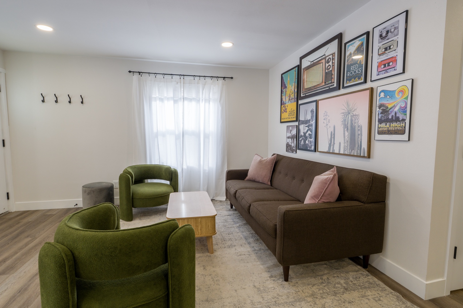 Sink into the stylish green seating and admire curated artwork in this bright, modern living space designed for relaxation.