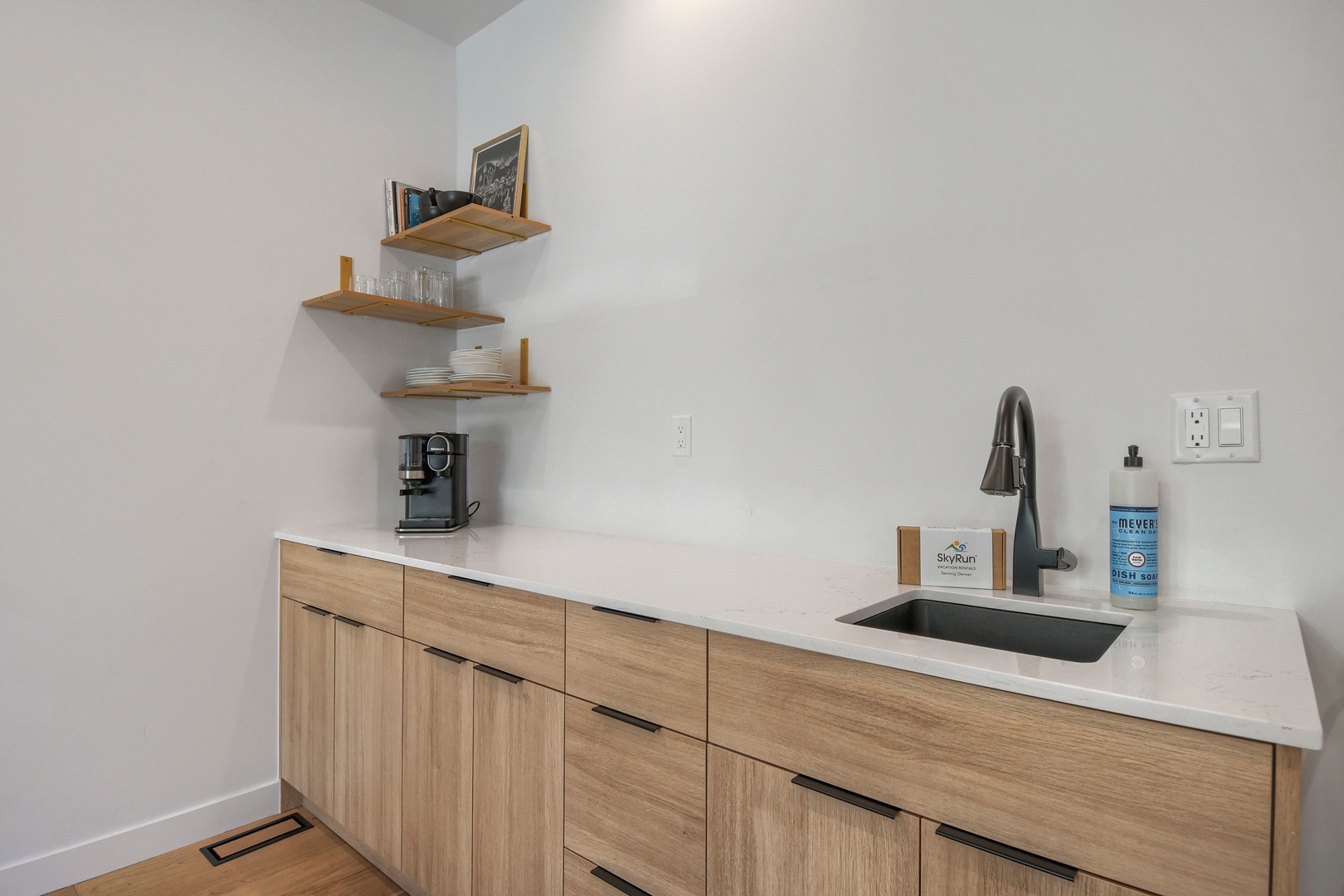 Your kitchenette corner combines clean lines and warm wood tones, making it easy to brew morning coffee or rinse fresh fruit at the sleek sink—everything within reach for a relaxed, unhurried stay.