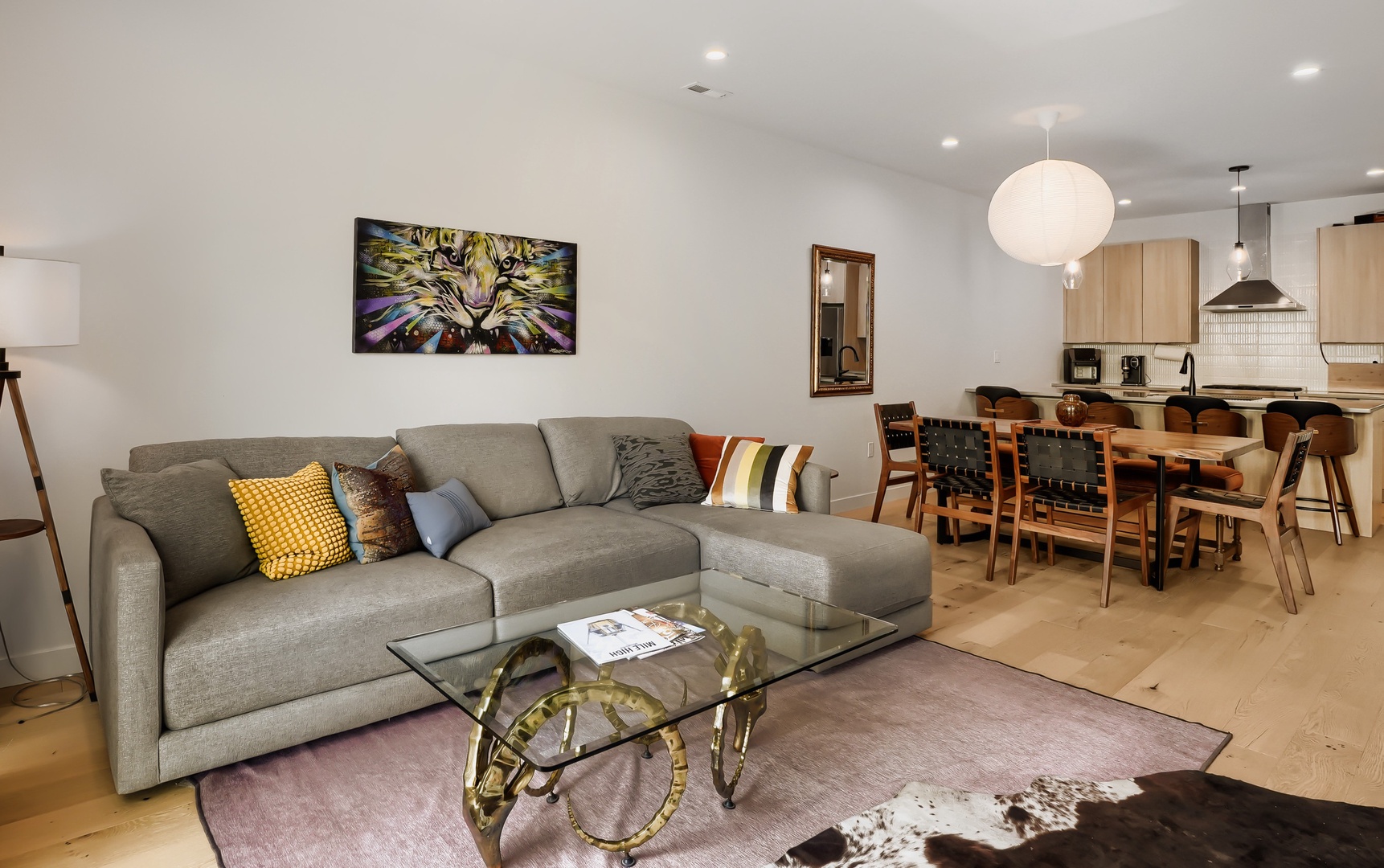 Unwind in your spacious open-plan living area where modern comfort meets warm design. Sink into the plush sofa, gather around the elegant dining table, and enjoy the fully-equipped kitchen—your perfect home base for creating vacation memories.