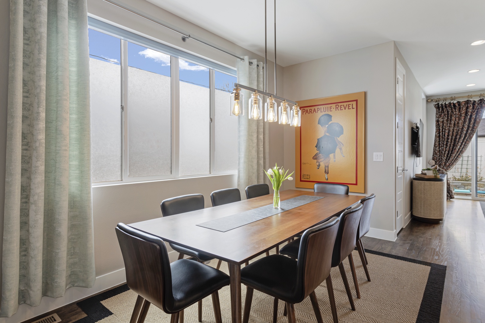 Gather around this sleek dining table where your group can share meals and plan adventures beneath stylish pendant lighting.