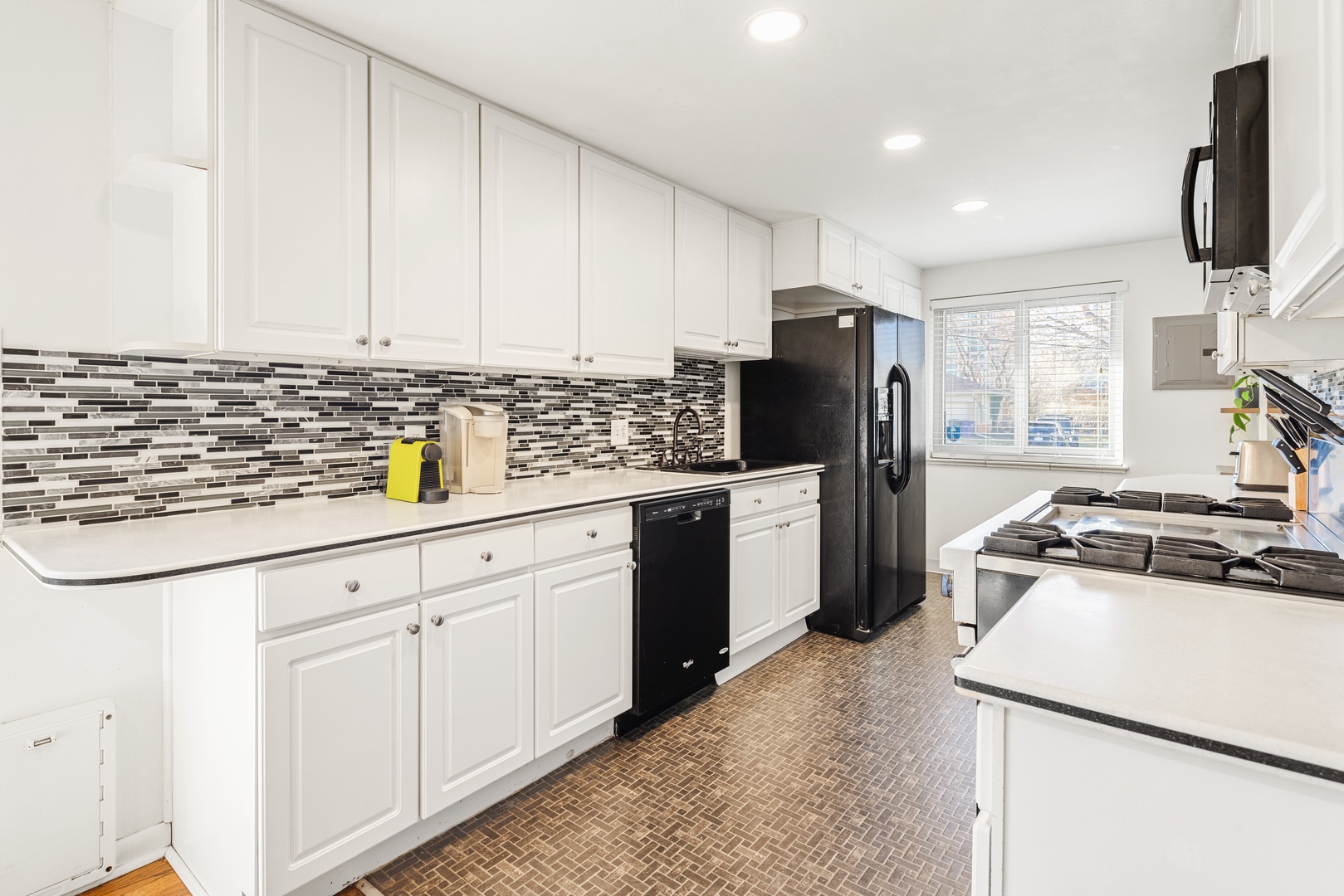 Your fully equipped kitchen features modern appliances and stylish tile backsplash, perfect for preparing meals during your stay.