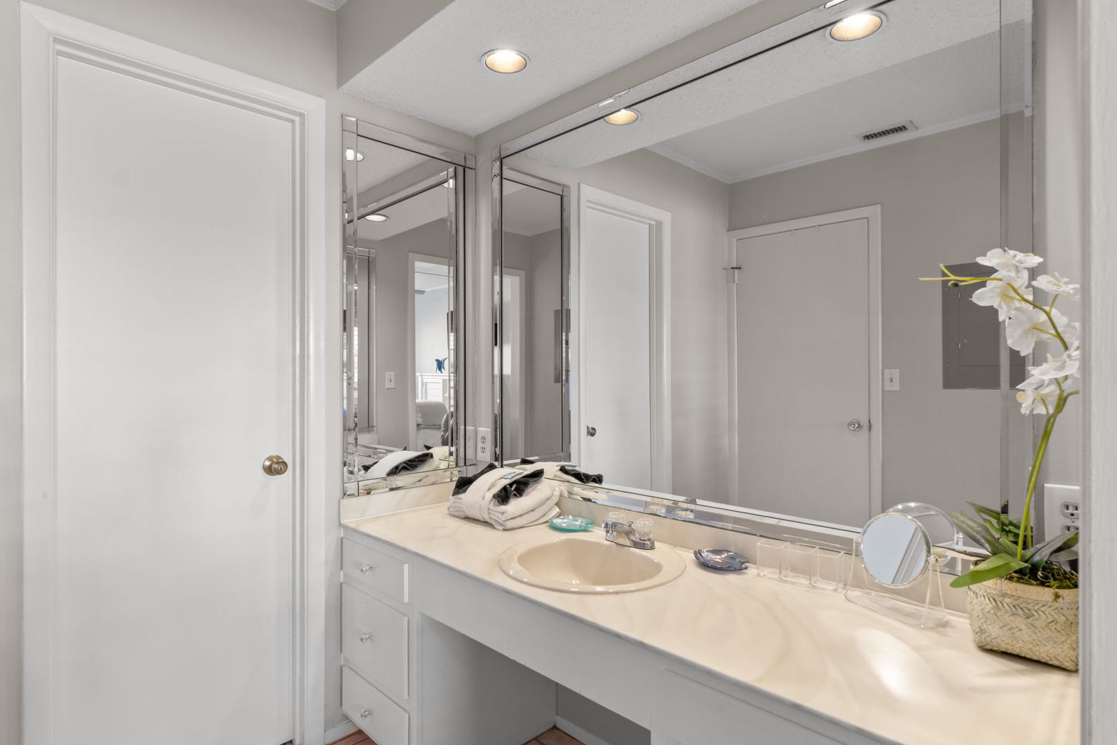 The dressing area features a spacious vanity with ample counter space, bright lighting, and large mirrors, creating the perfect spot to get ready for a day at the beach or an evening out.